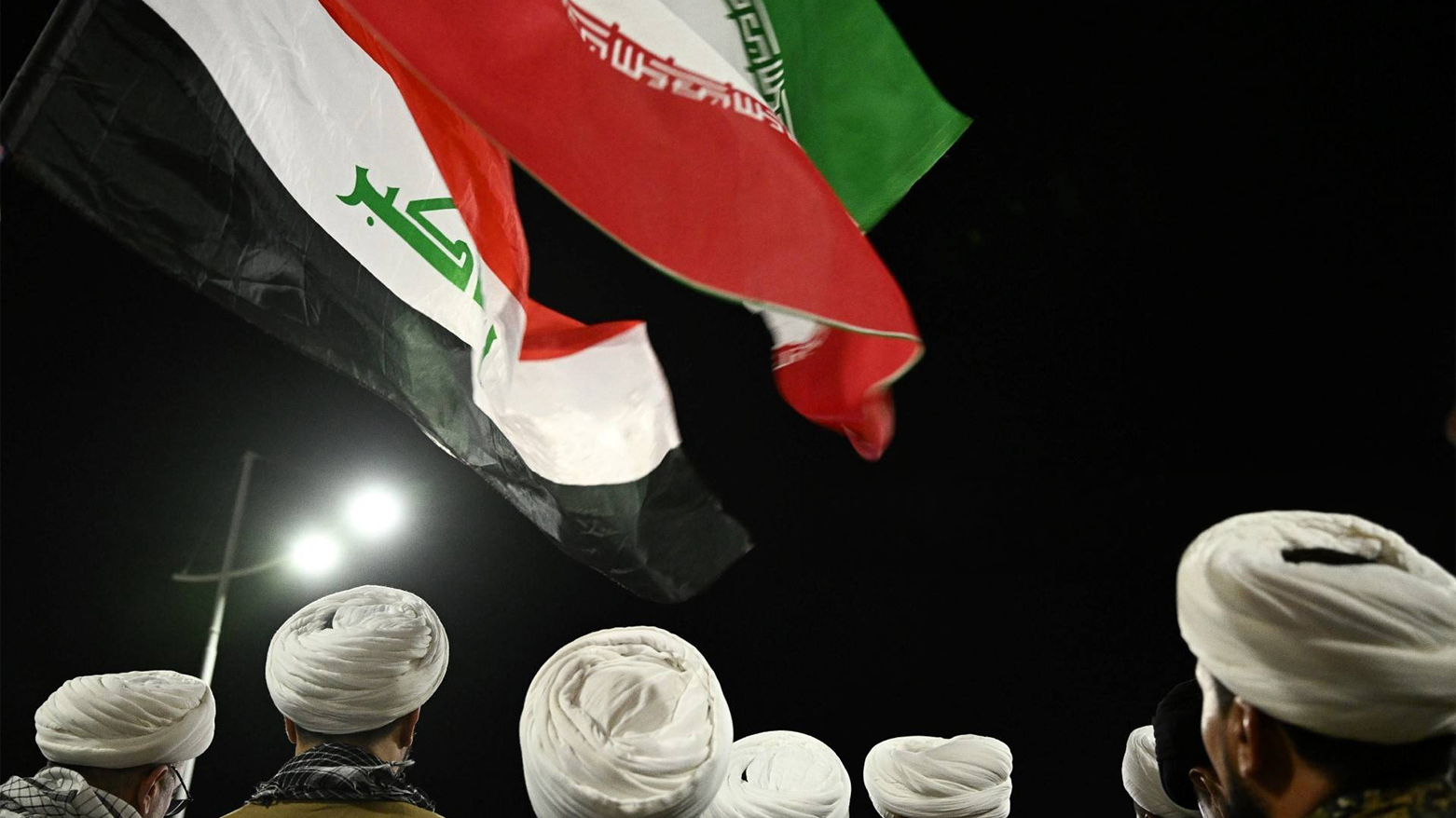 Shiite clerics in uniform wave Iranian and Iraqi flags during a June 18 rally protesting Israeli strikes on Iran. (Photo: AFP)
