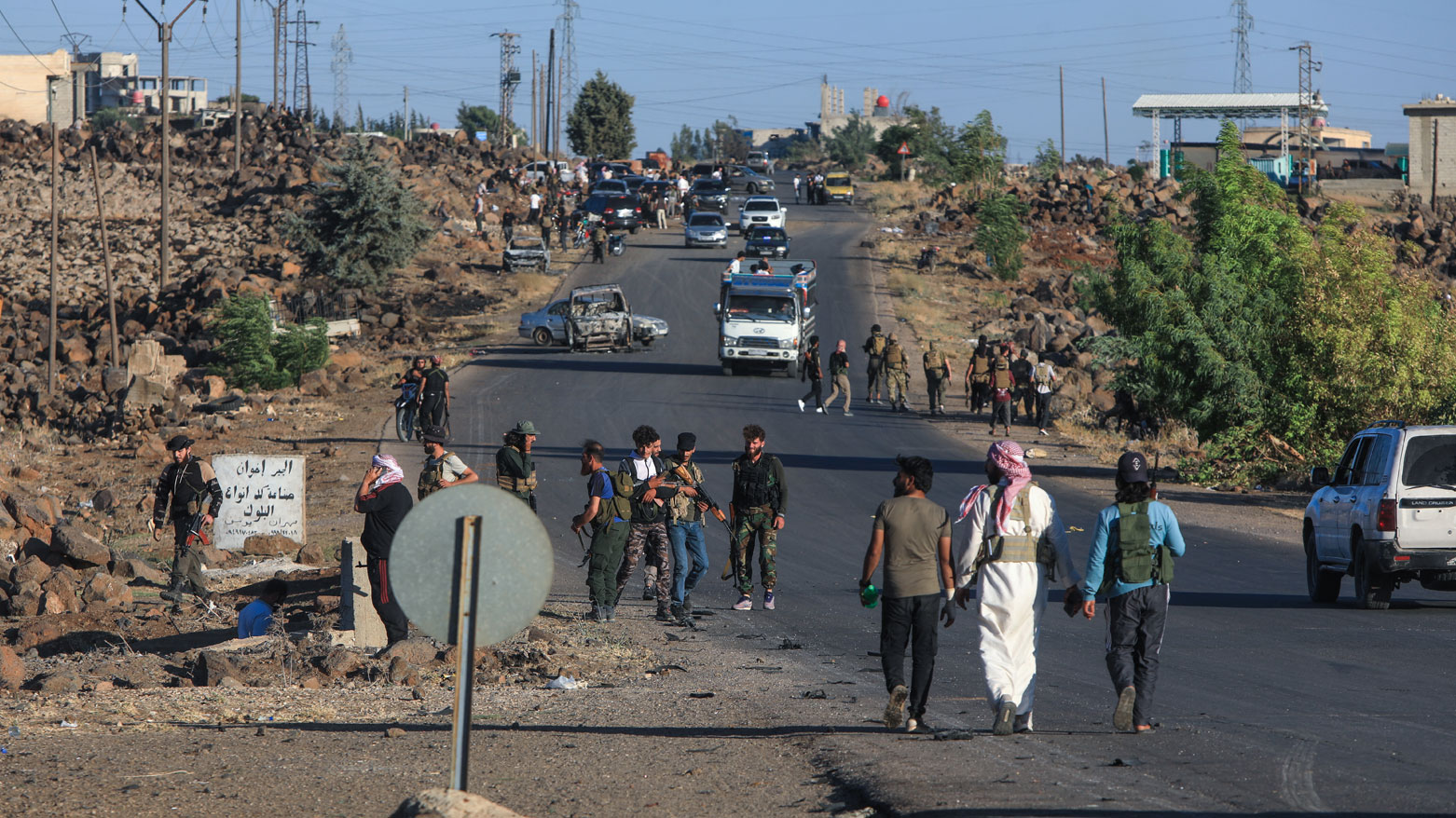 مقاتلون من البدو والعشائر عند المدخل الغربي لمدينة السويداء (فرانس برس)