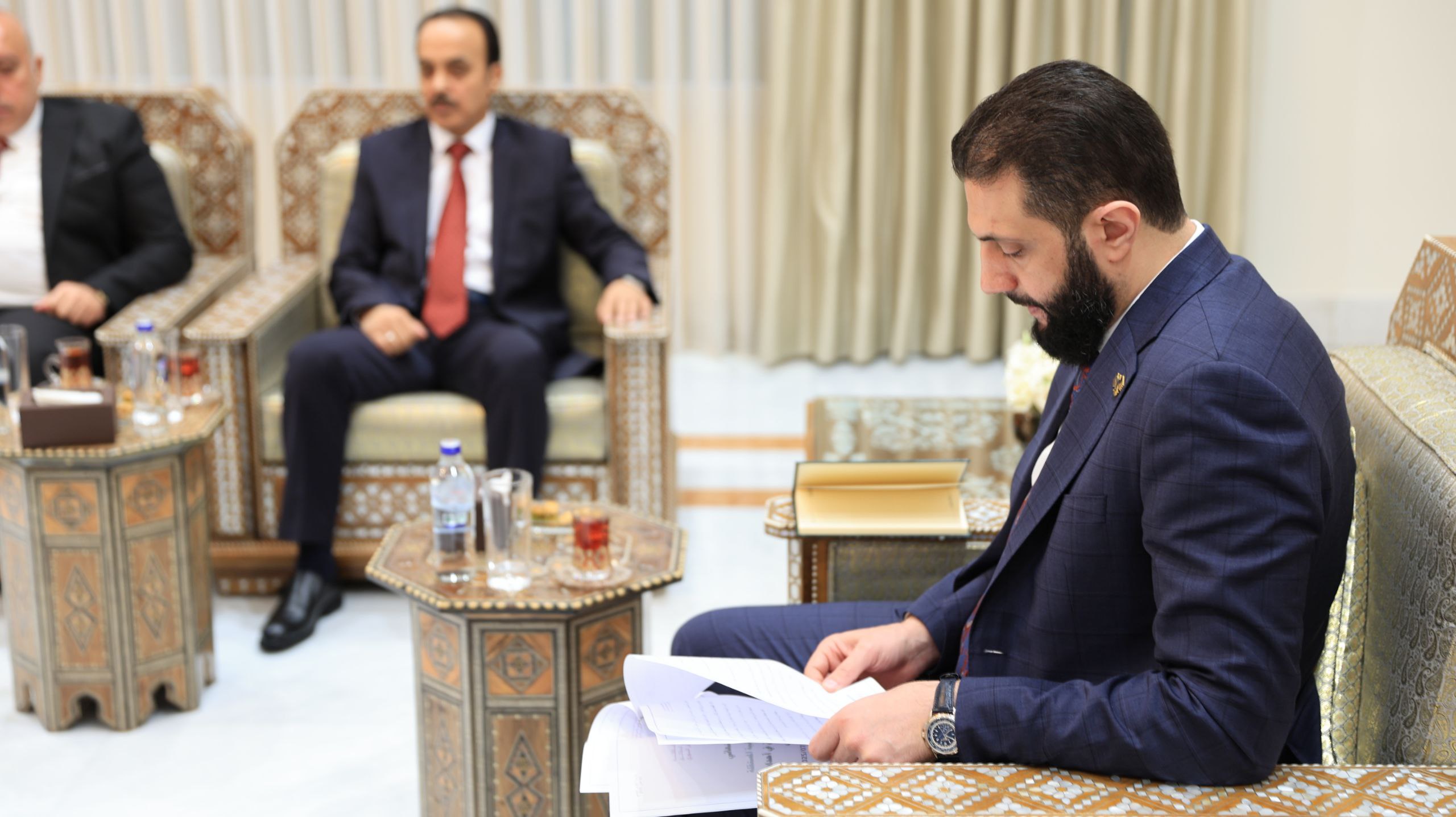 Syrian Interim President Ahmed Al-Sharaa reading the reported presented by the National fact-finding Committee. (Photo: SANA)