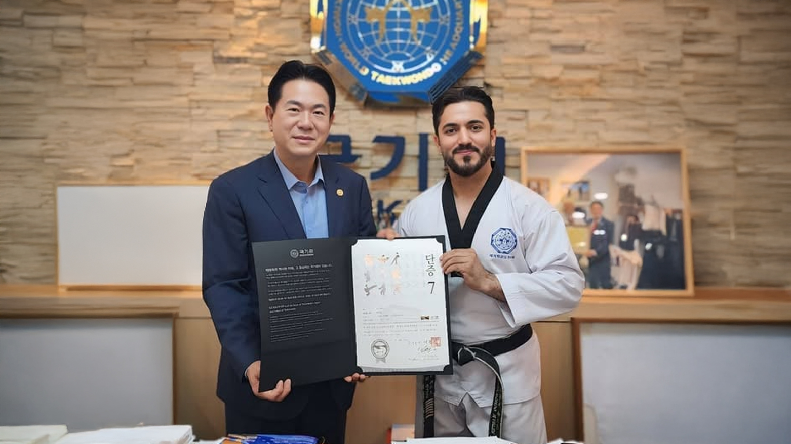 Hemin Mehdi Qadir receiving his certificate from Lee Dong-sup, the President of the World Taekwondo Headquarters. (Photo: Kurdistan24)