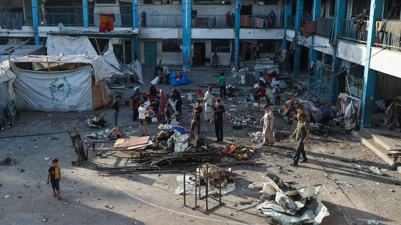فلسطينيون ينقذون أشياء من حطام خيمة تعرضت للقصف الإسرائيلي في مخيم البريج وسط غزة (فرانس برس)