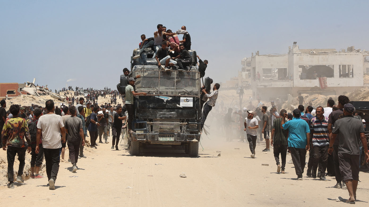 يندفع الناس نحو شاحنة محملة بالمساعدات الإنسانية على طول شارع الرشيد غرب جباليا في غزة (فرانس برس)