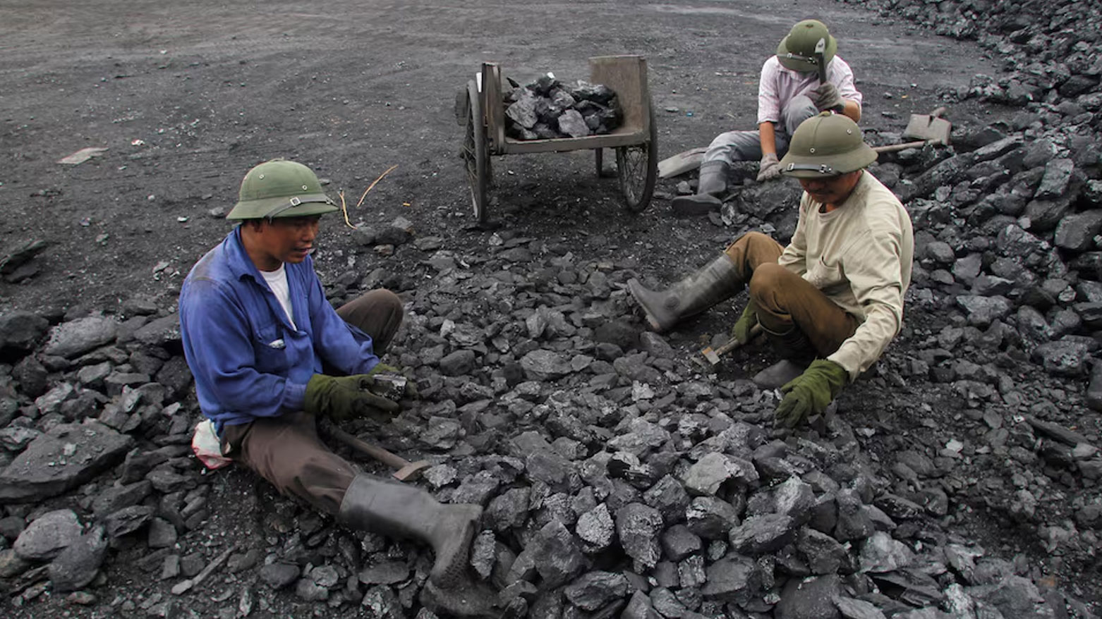 عمال يجمعون الحصى من الفحم في ميناء للفحم في هانوي بفيتنام (تعبيرية- رويترز)
