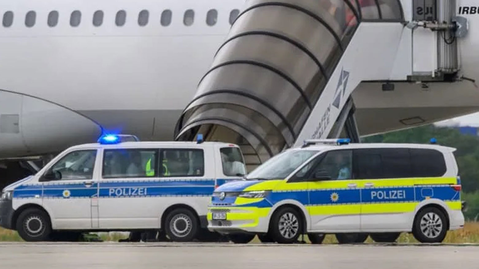 Passengers sit in a police vehicle before boarding a deportation flight at Leipzig/Halle Airport. A plane bound for Baghdad was stationed at the airport earlier in the morning, suggesting another deportation operation may be underway. (Photo: dpa)