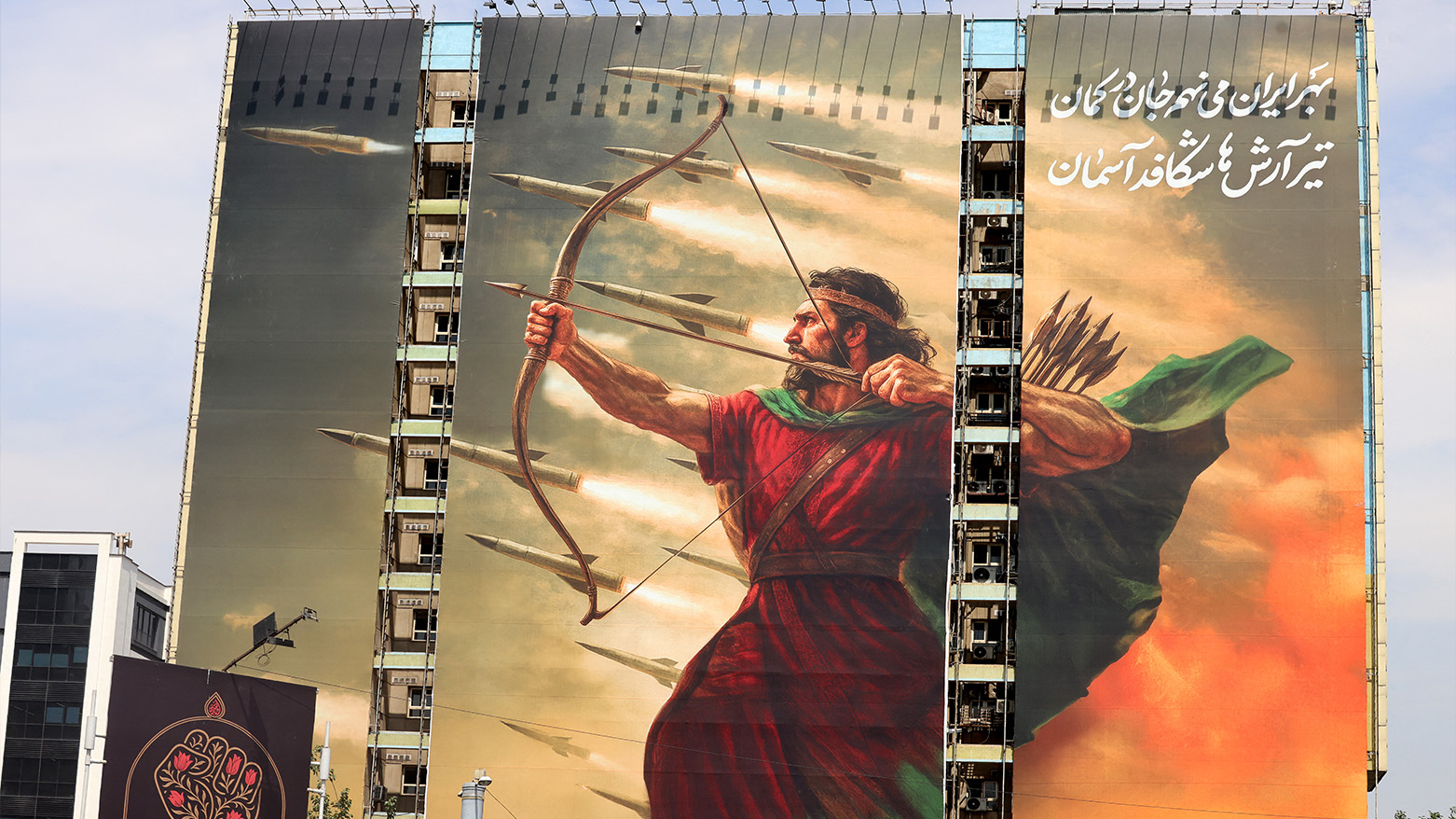 photo from Tehran's Vanak Square shows a new billboard depicting the mythical Persian archer Arash, with a Farsi poem excerpt: 'For Iran, I place my soul in the bow... The arrow of Arash breaks through the sky.' on Jul. 16, 2025. (Photo: AFP)