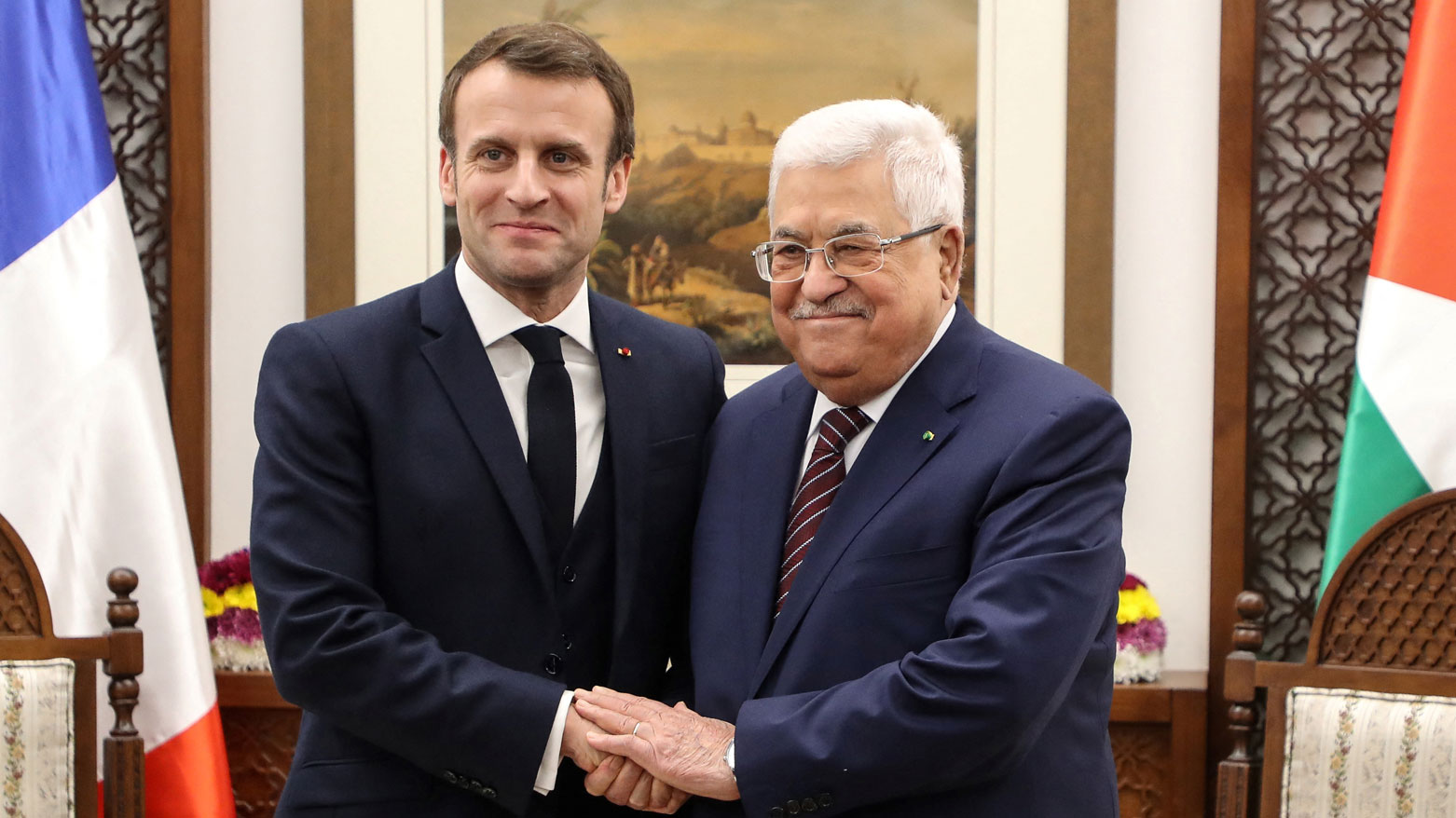 ماكرون يصافح الرئيس الفلسطيني في مقره بمدينة رام الله بالضفة الغربية عام 2020 (فرانس برس)