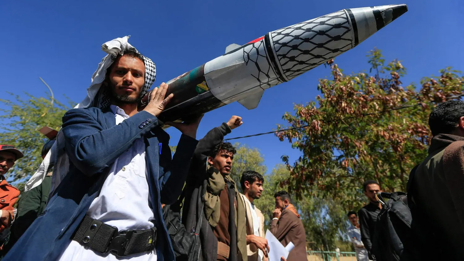 A man carries a mock missile in the Houthi-controlled capital Sanaa on January 1, 2025. (AFP)