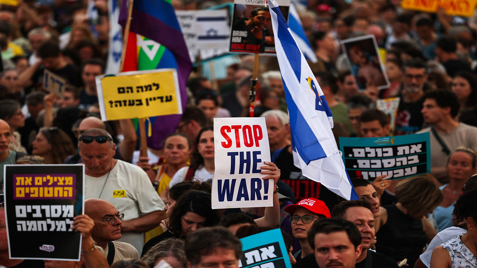 Demonstrators lift placards and flags during an anti-government protest in in Tel Aviv on July 24, 2025. (Photo: AFP)