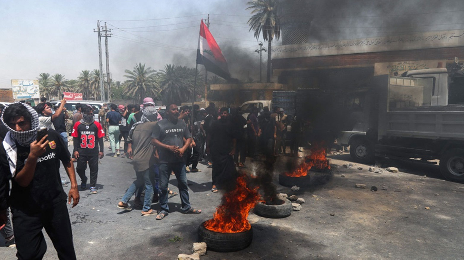 People block a road with burning tyres as they protest water shortages and the drying up of rivers, on the main road linking the Babil and Qadisiyah governorates in the Al-Majriya area of central Iraq's Hilla city on Jul. 25, 2025. (Photo: AFP)