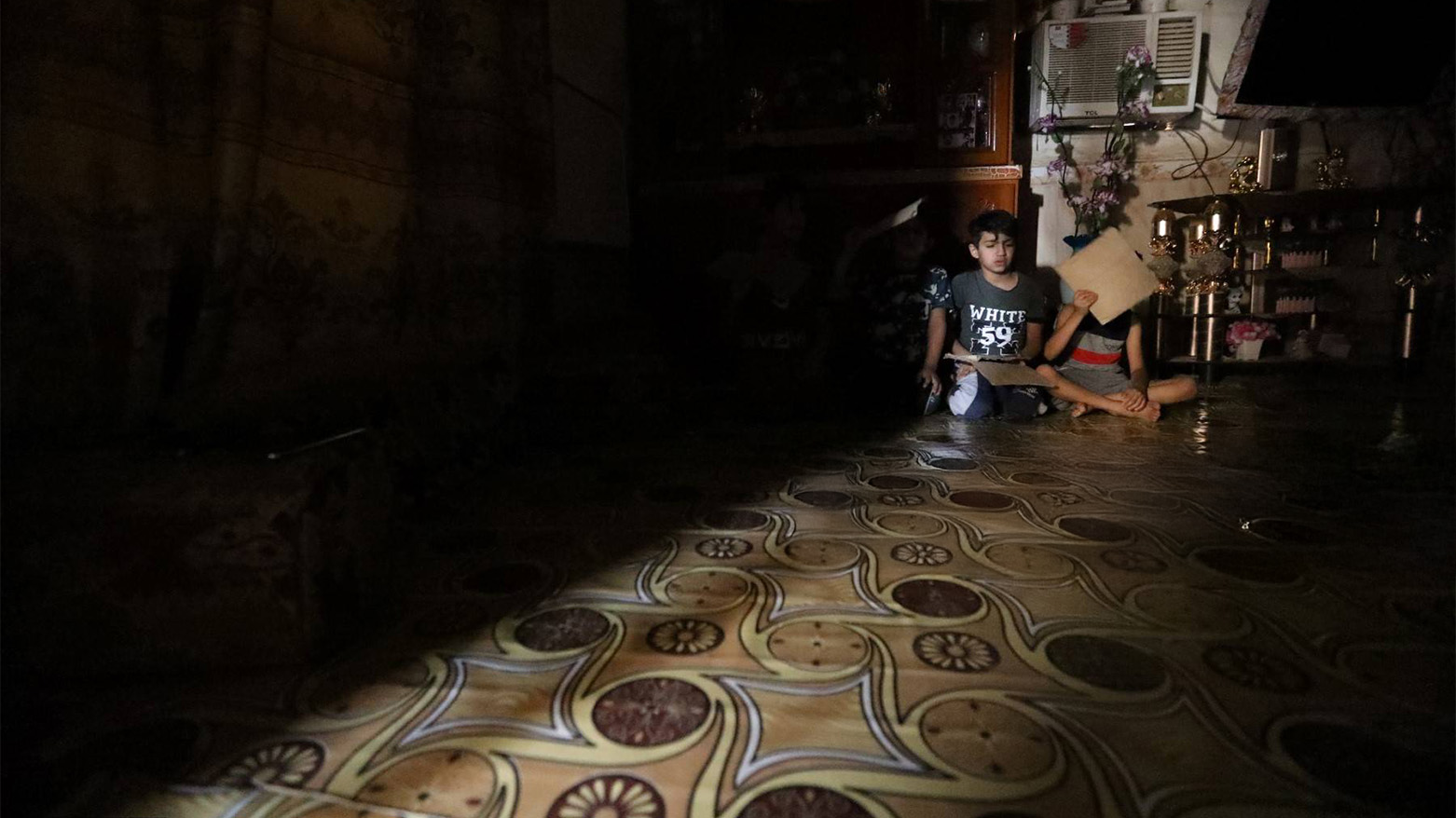 Iraqi children sit in their home in Nasiriyah, southern Iraq as it faces drought, sandstorms, and falling river levels after decades of conflict. (AFP)