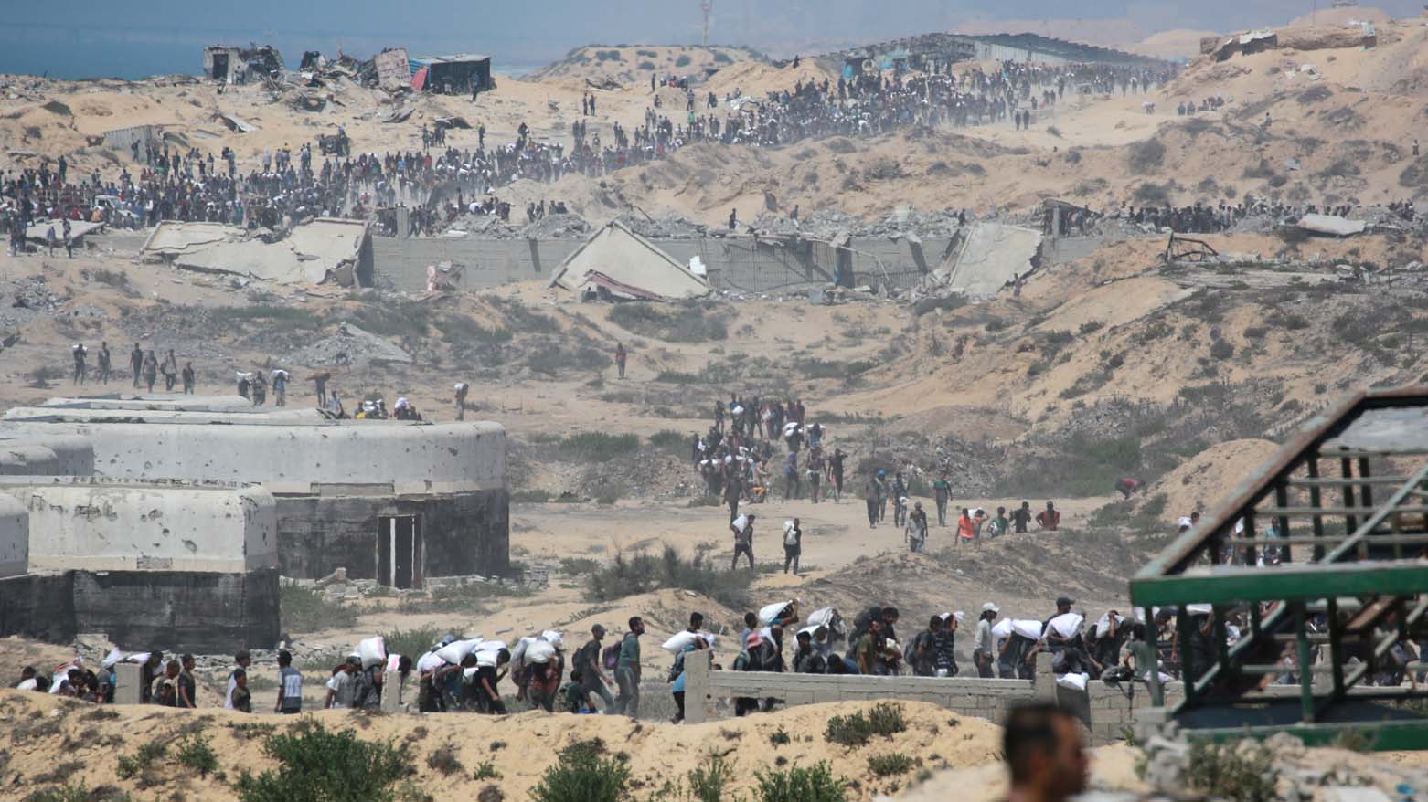 فلسطینی‌ها در حال حمل کیسه‌های آرد در شمال نوار غزه، ۲۷ جولای ۲۰۲۵، پس از ورود کامیون‌های حامل کمک‌های بشردوستانه از گذرگاه مرزی زیکیم به شمال غزه – عکس: خبرگزاری فرانسه