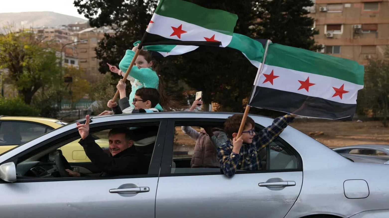 People wave independence-era Syrian flags during celebrations for the ousting of president Bashar al-Assad in the capital Damascus on December 20, 2024. (Photo: AFP)