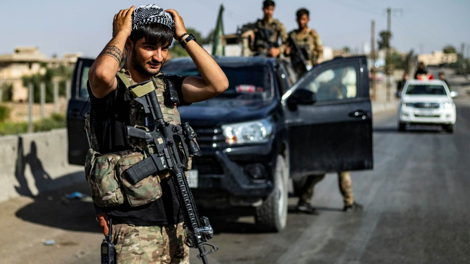 A fighter of the Syrian Democratic Forces (SDF) stands guard along a road. (AFP)