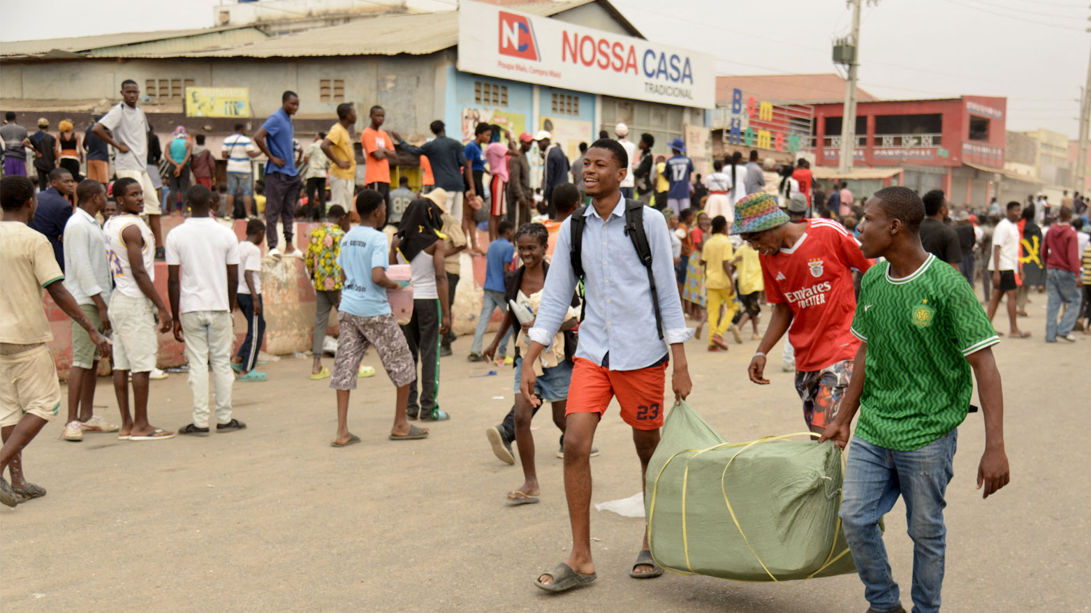 يحمل السكان بعض الأغراض بينما اندلعت أعمال نهب في منطقة كاليمبا 2 بلواندا خلال إضراب عام (فرانس برس)