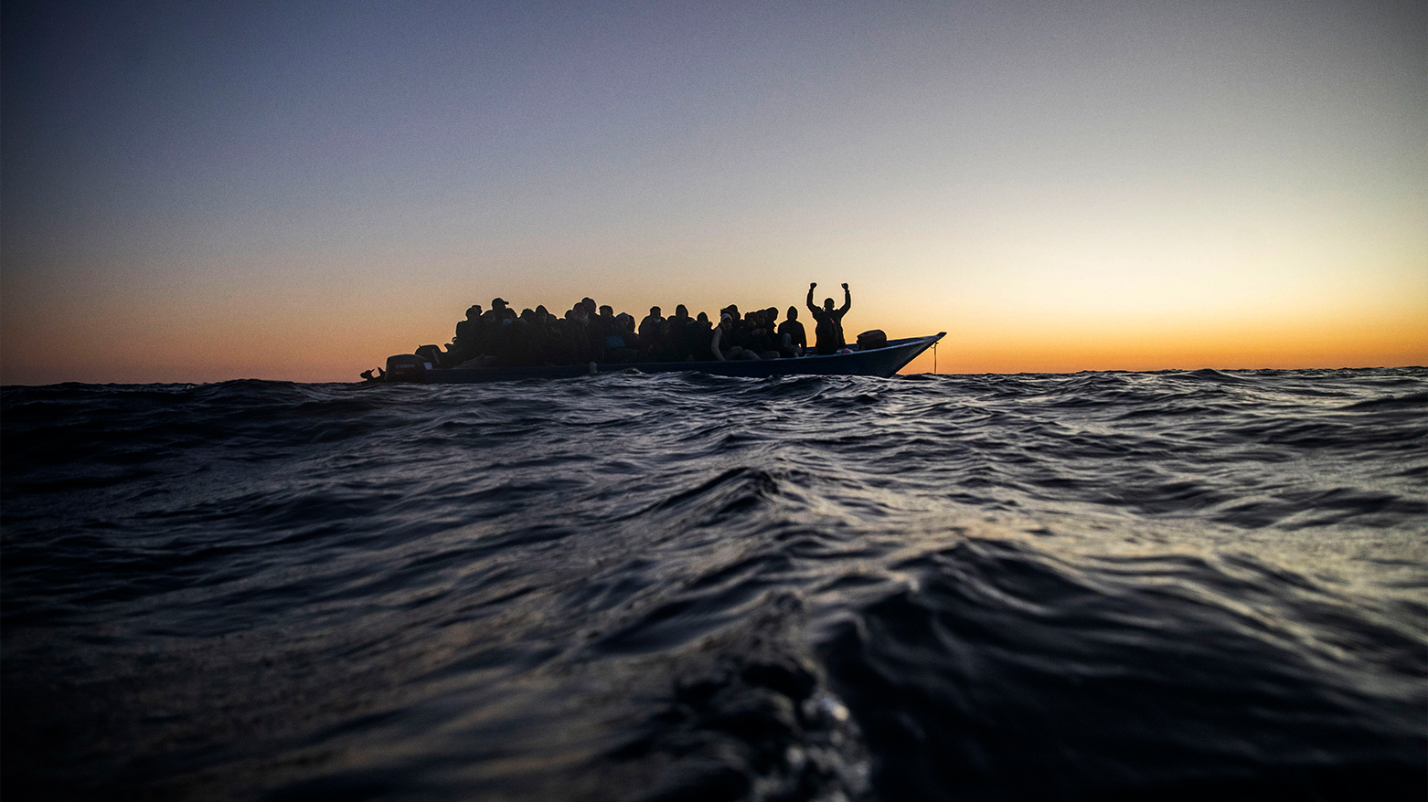 Migrants and refugees await aid on an overcrowded boat off Libya's coast, Feb. 12, 2021. (AP)