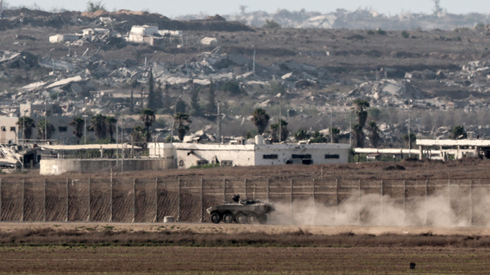An Israeli armoured vehicle near the separation fence and the destruction in the besieged Palestinian territory on August 7, 2025. (Photo: AFP)