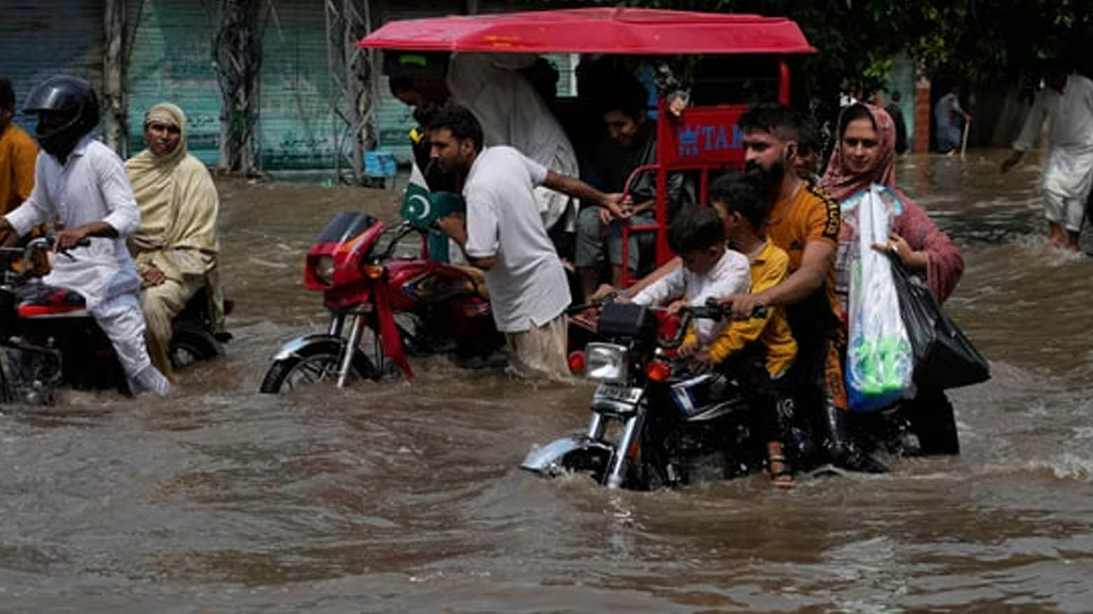 رانندگان در حال عبور از جاده‌ای آب گرفته ناشی از باران شدید موسمی در لاهور، پاکستان -عکس: خبرگزاری آسوشیتدپرس