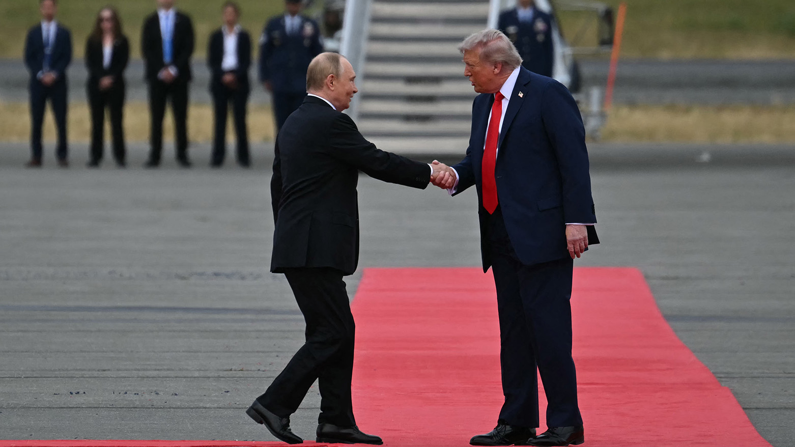 US President Donald Trump (R) greets Russian President Vladimir Putin on the tarmac after they arrived at Joint Base Elmendorf-Richardson in Anchorage, Alaska, on Aug. 15, 2025. (AFP)