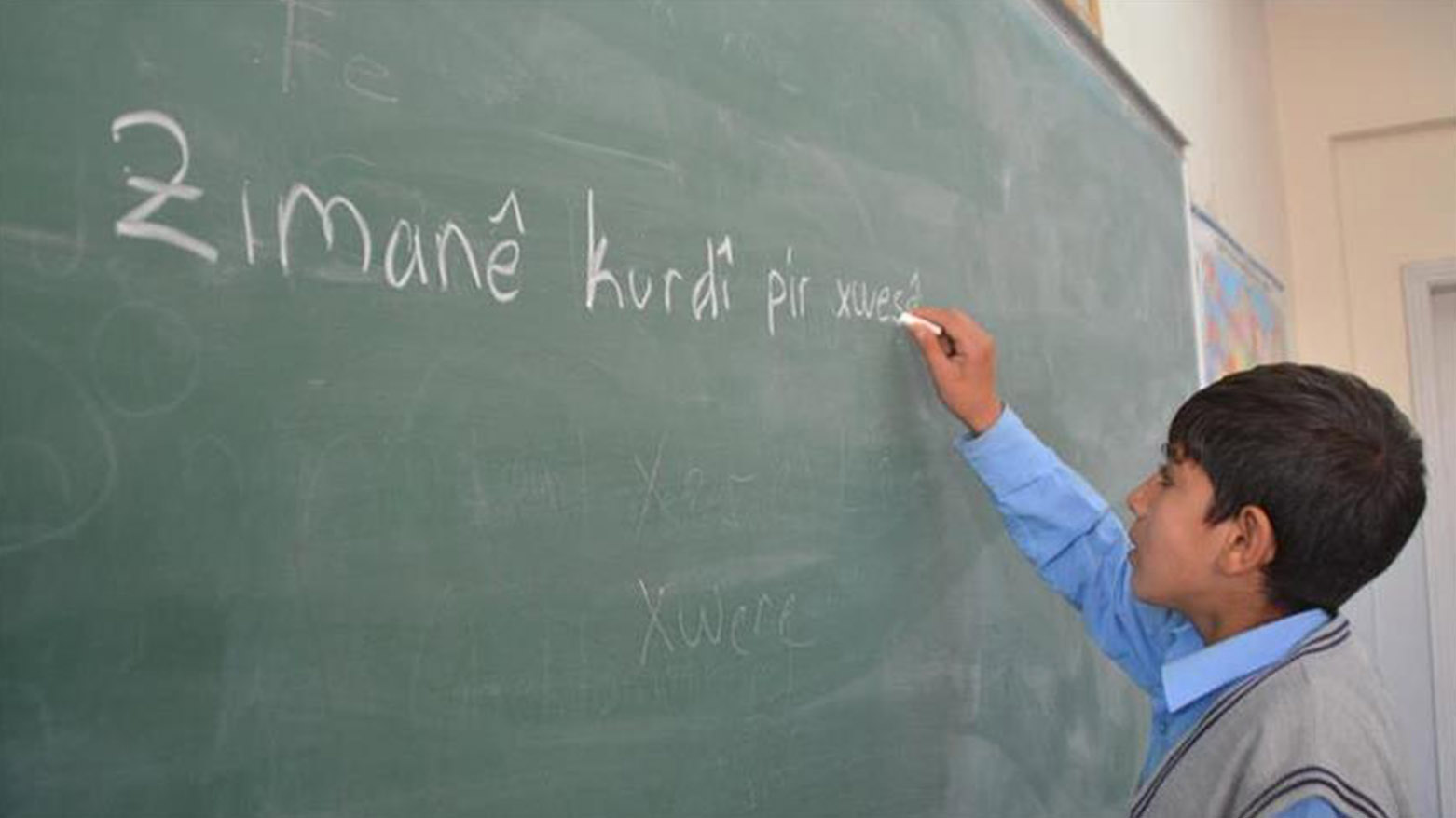 A Kurdish student writes the sentence "The Kurdish language is very beautiful" on the blackboard. (Photo: Social Media)