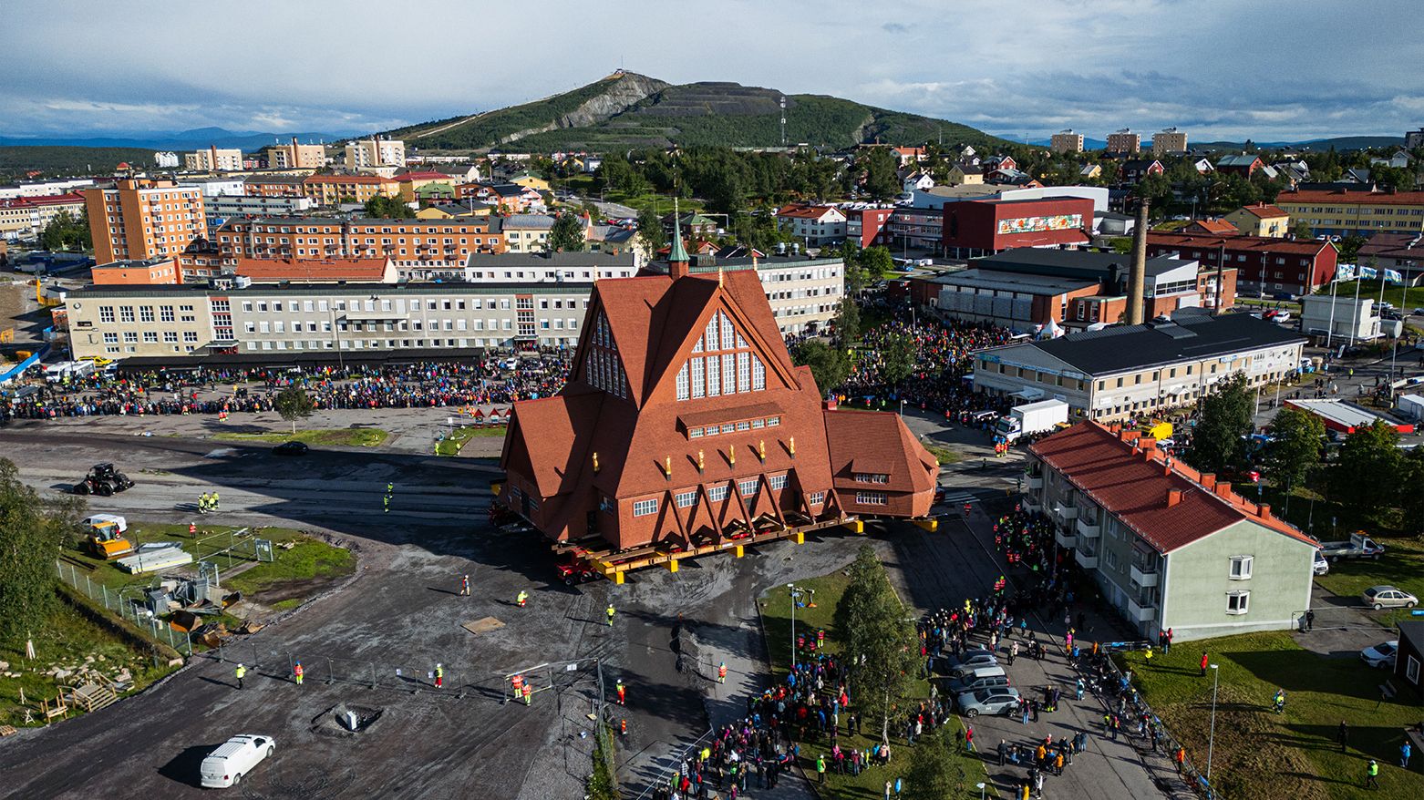 An aerial view shows people gathered to watch the moving of the wooden Kiruna Church, in Kiruna, Sweden on Aug. 19, 2025. (AFP)