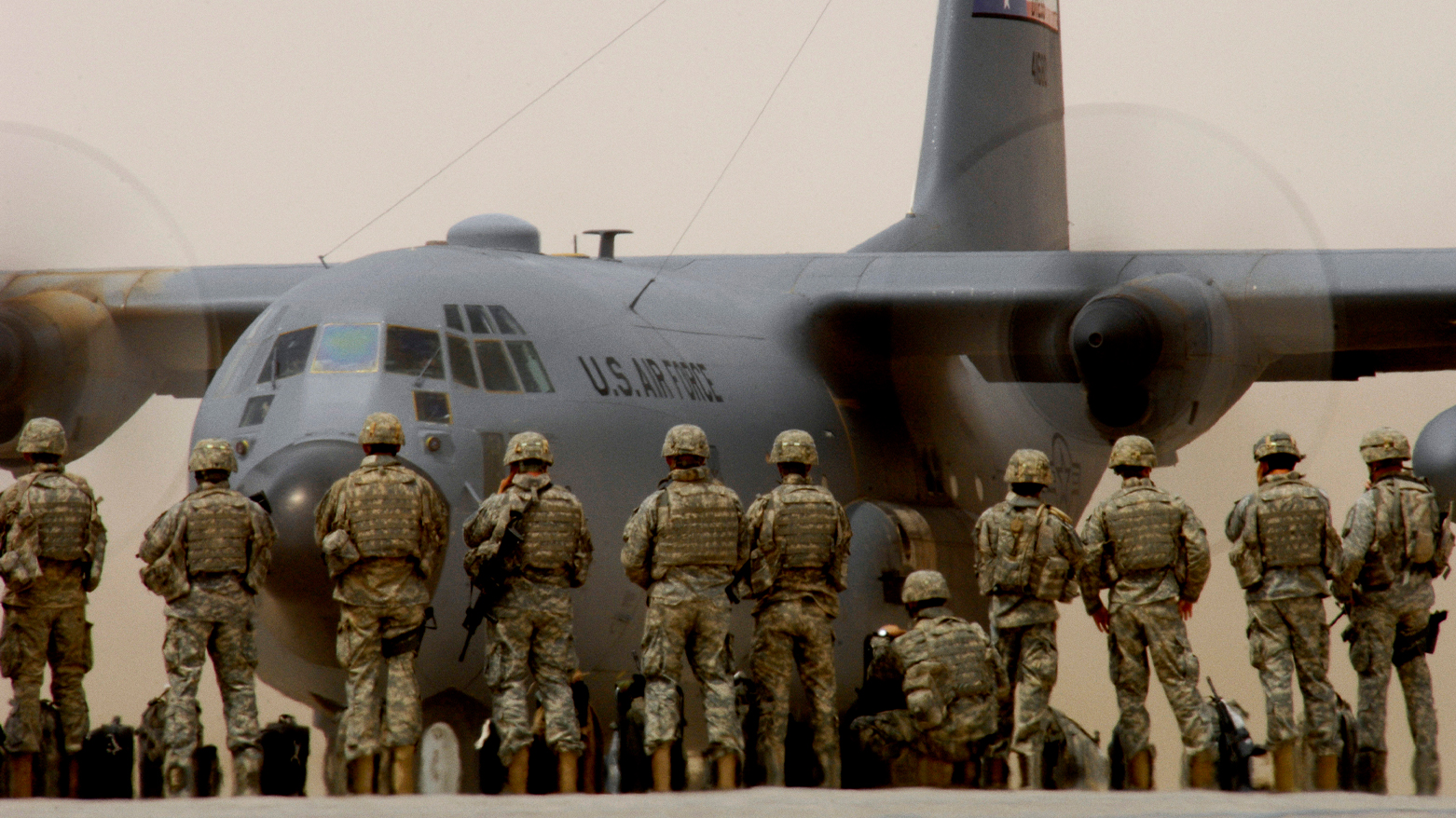 U.S. Army soldiers watch a C-130 Hercules aircraft taxi. (Photo: DVDIS)