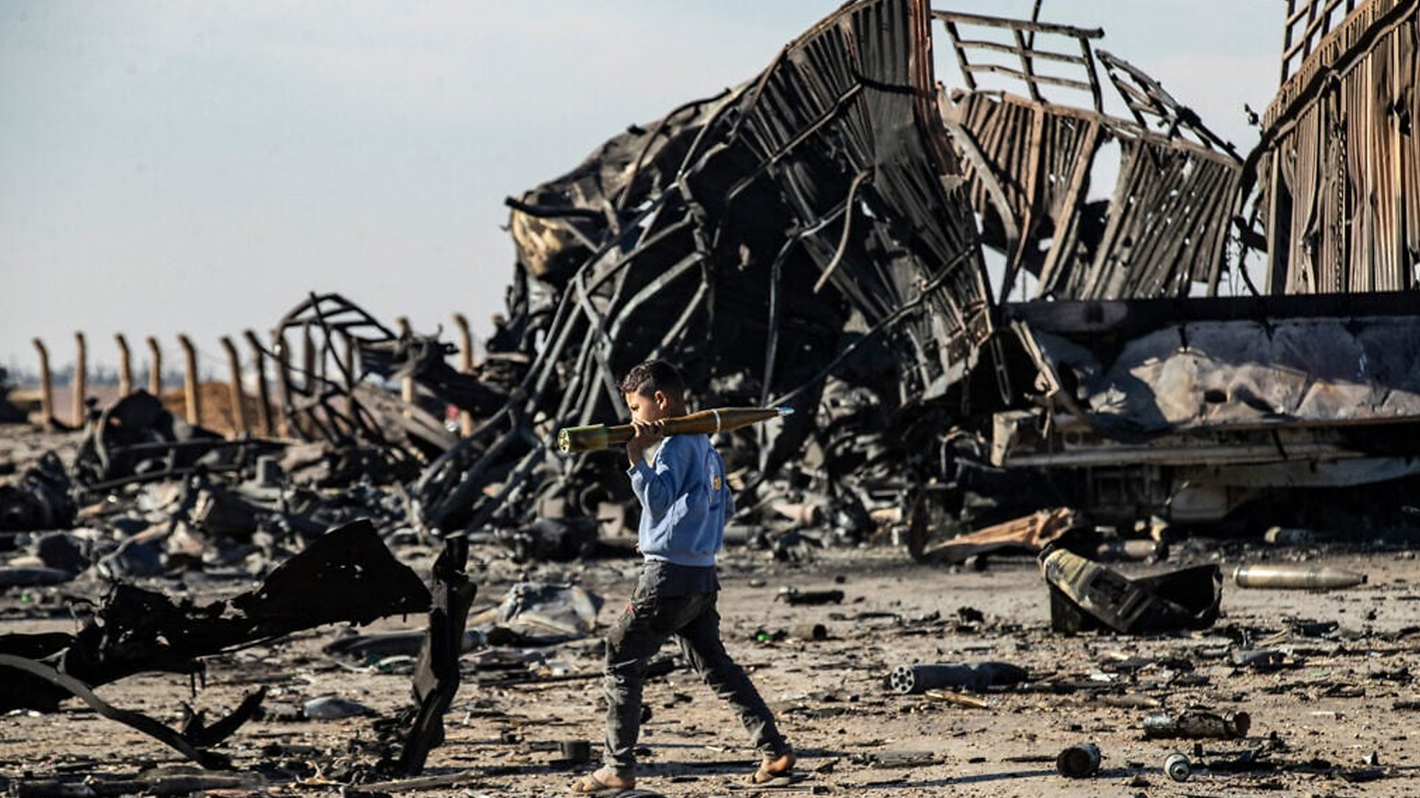 Boy carries unexploded RPG at site of Israeli airstrike targeting Syrian weapons in northeastern Syria, Dec. 10, 2024.