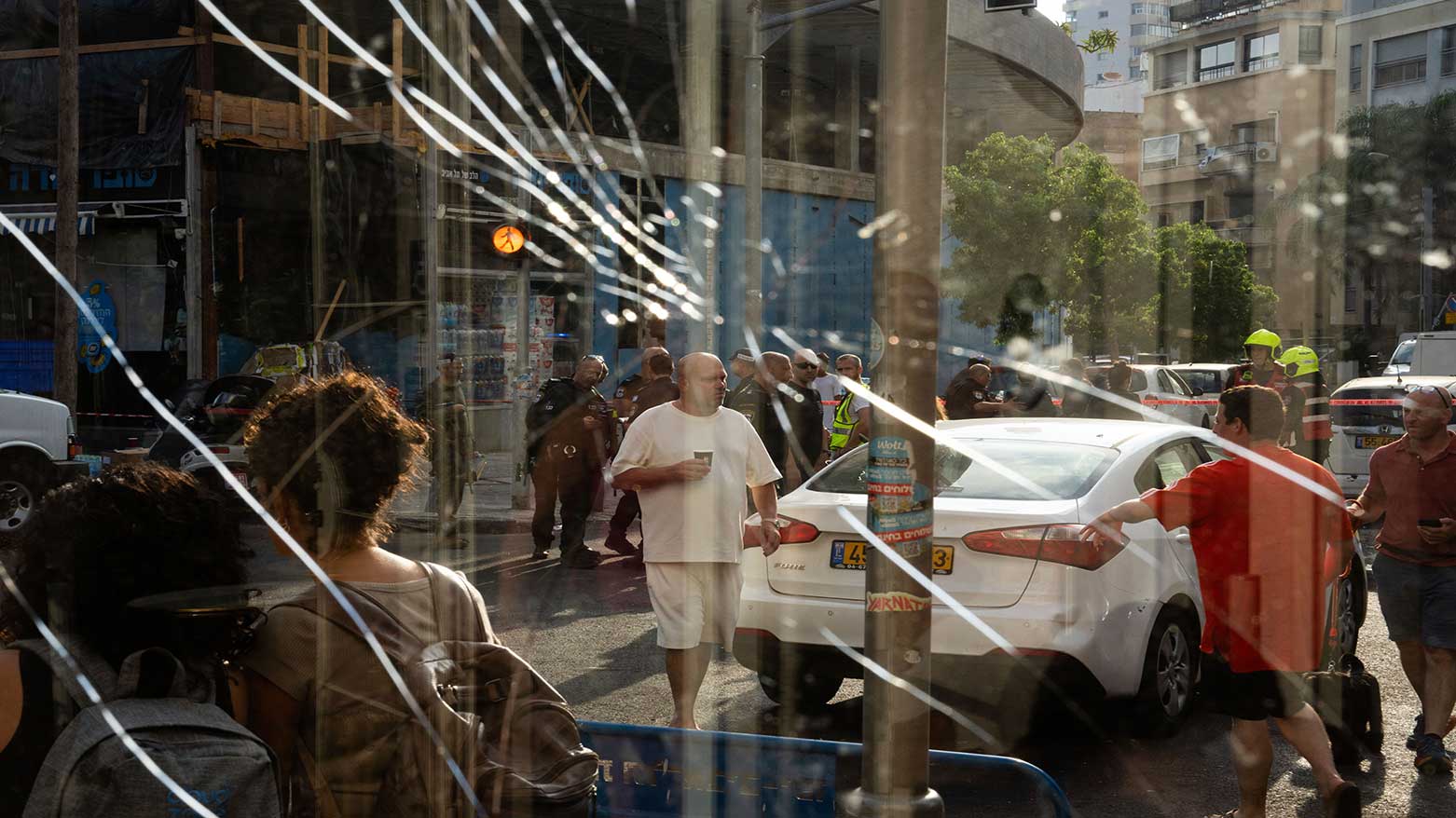 People stand by a shattered window after a Houthi drone attack in Tel Aviv, July 19, 2024, that killed one and injured at least 10. (Photo: AP)