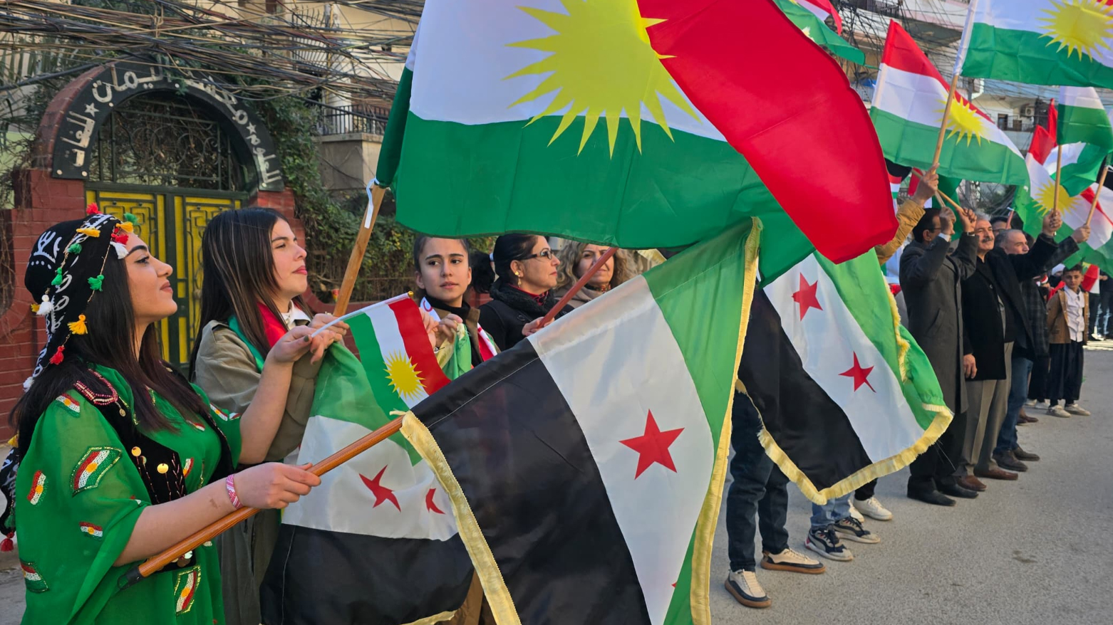 Kurdish demonstrators wave Kurdish and Syrian flags at a rally. (Photo: Social Media)