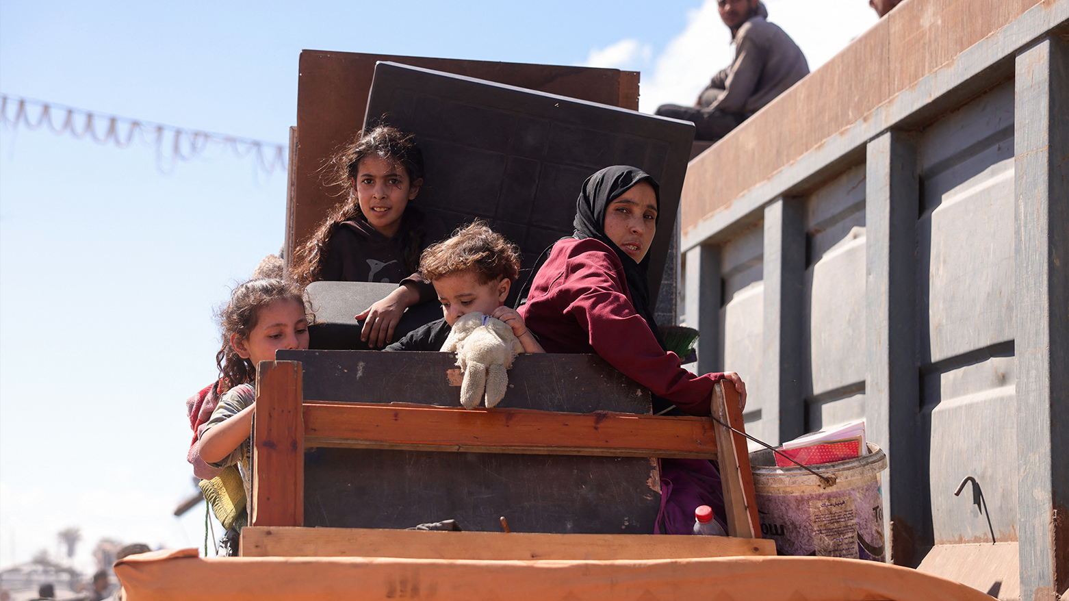 Palestinians carrying belongings arrive on a coastal path northwest of Nuseirat refugee camp. (AFP)