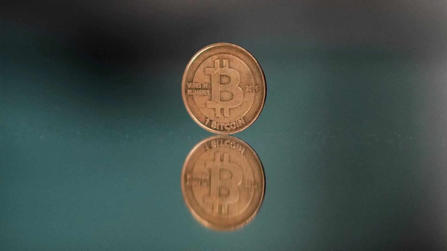 A bitcoin token is placed on a mirror for a photograph. (AP)