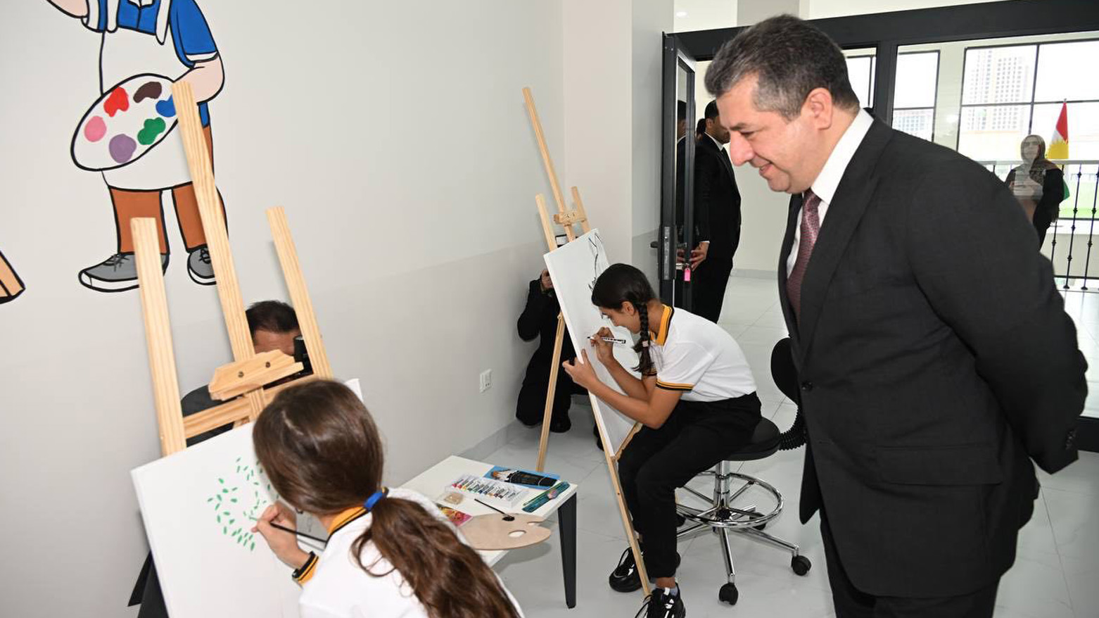 PM Masrour Barzani observes two students painting during a school visit. (Photo: Kurdistan24)