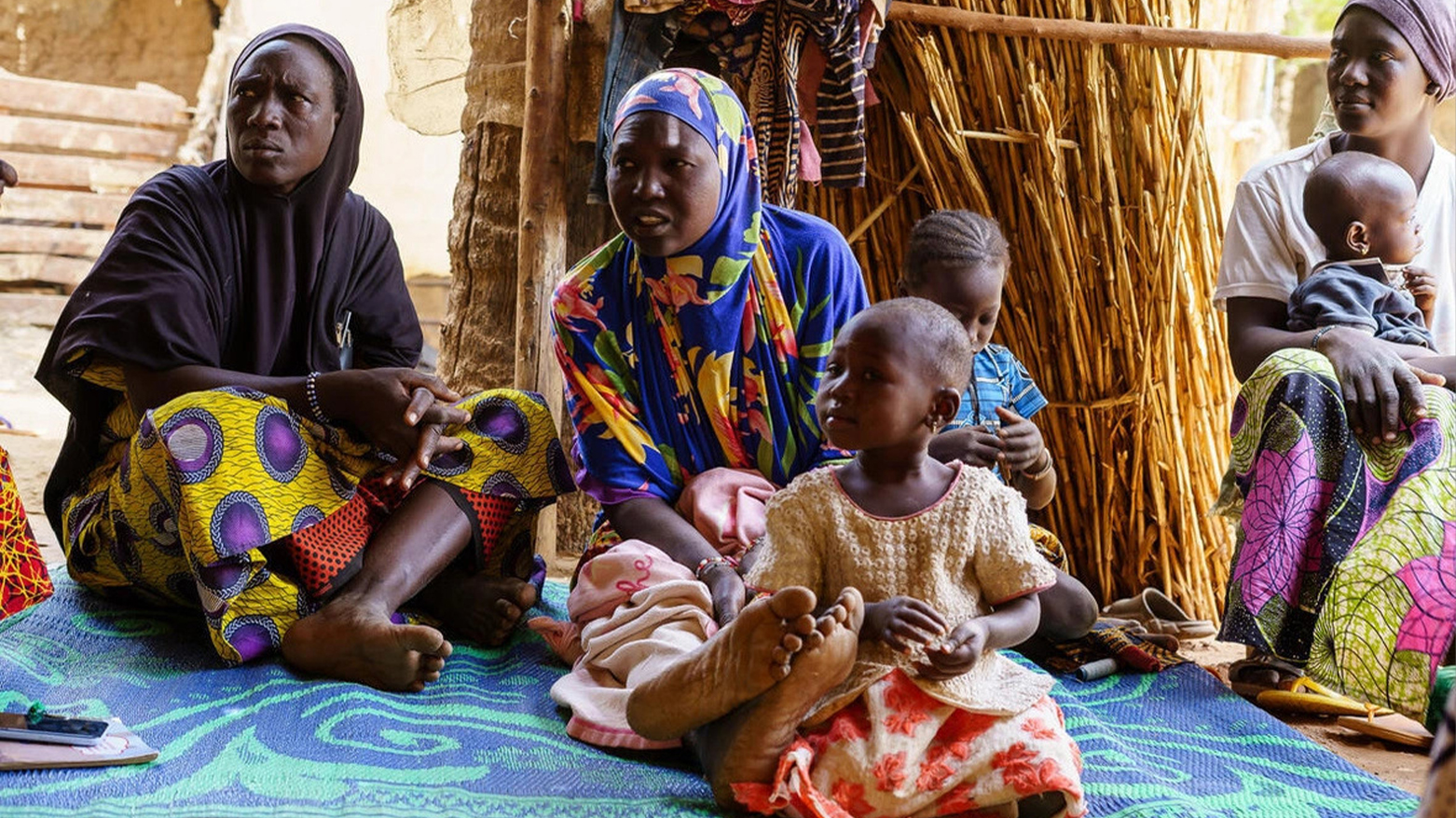 Women and children sit in a shelter in March 2024 at a site in Soucoura, Mali, hosting refugees from Burkina Faso who fled violence. (UN)