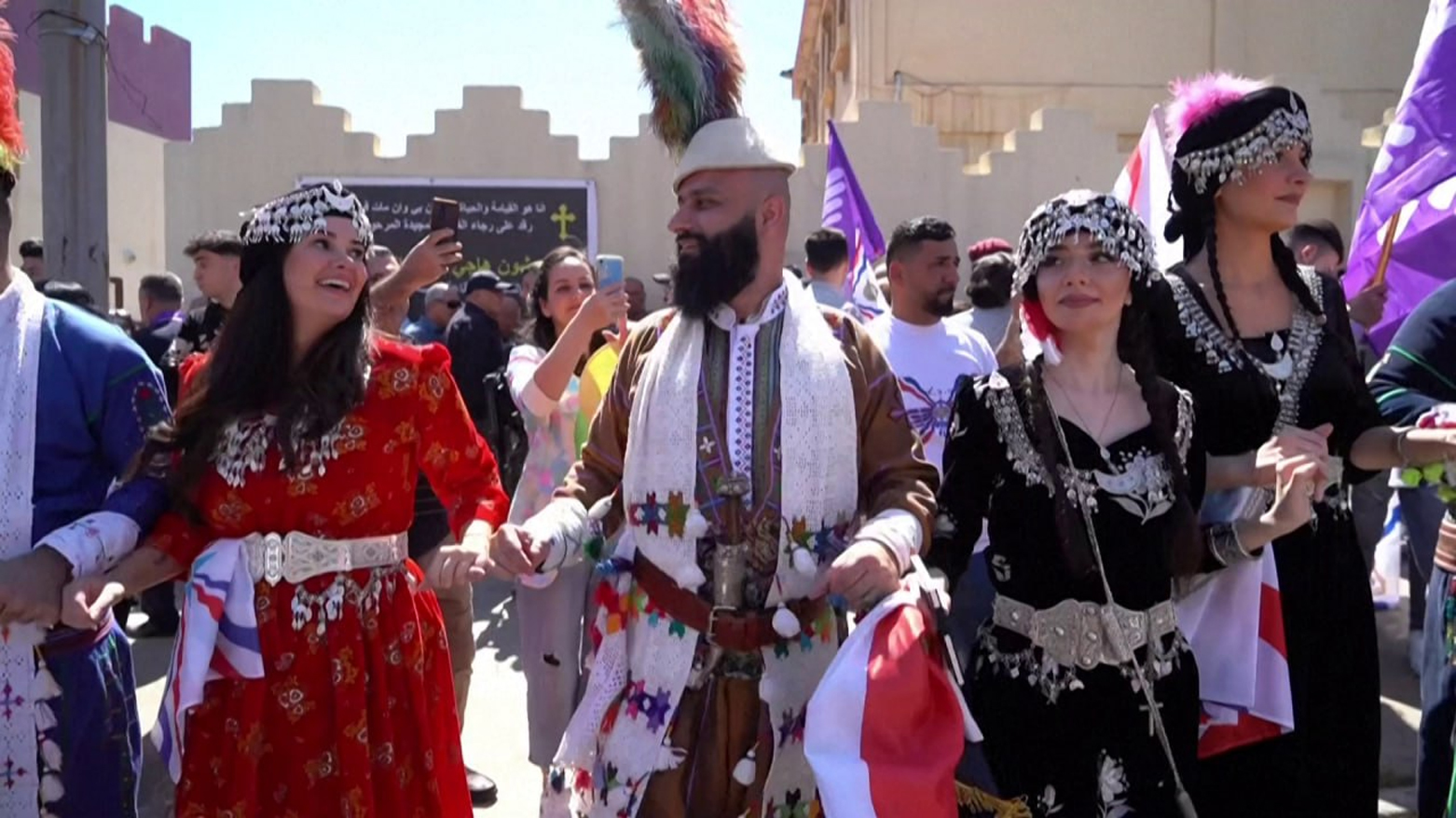 Dressed in their traditional clothing, Christians dance and wave flags as they march to the sound of a music troupe during "Aketo" celebration, Dohuk. (Photo: AFP)