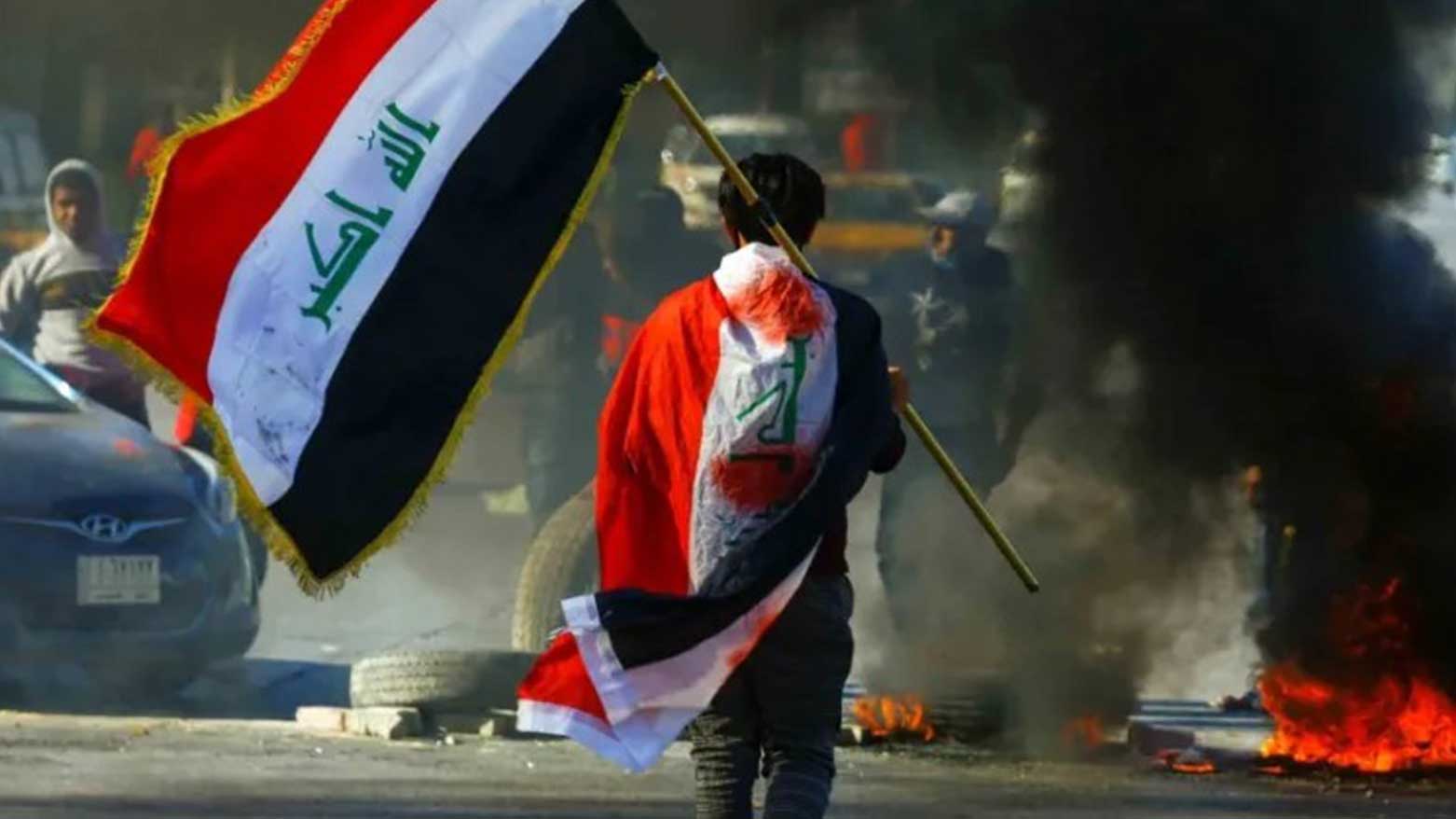 A demonstrator carries an Iraqi flag during an antigovernmental protest in Najaf, Iraq, Sep. 30, 2020. (Photo: Social Media)