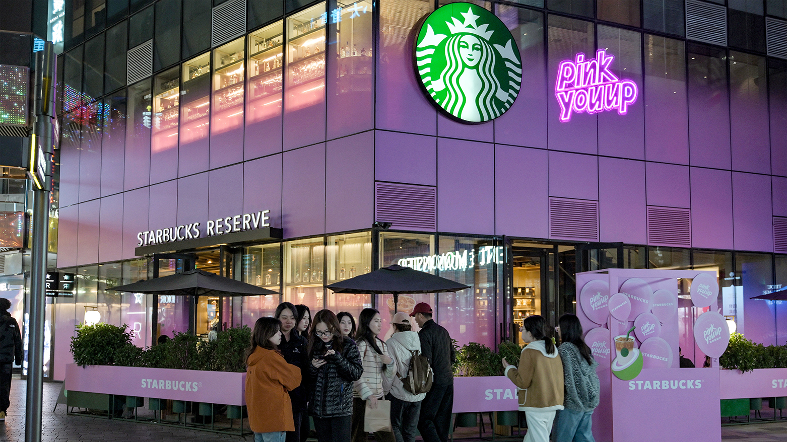 People walk past a Starbucks Reserve at the Sanlitun shopping area in Beijing on Oct. 30, 2025. (AFP)