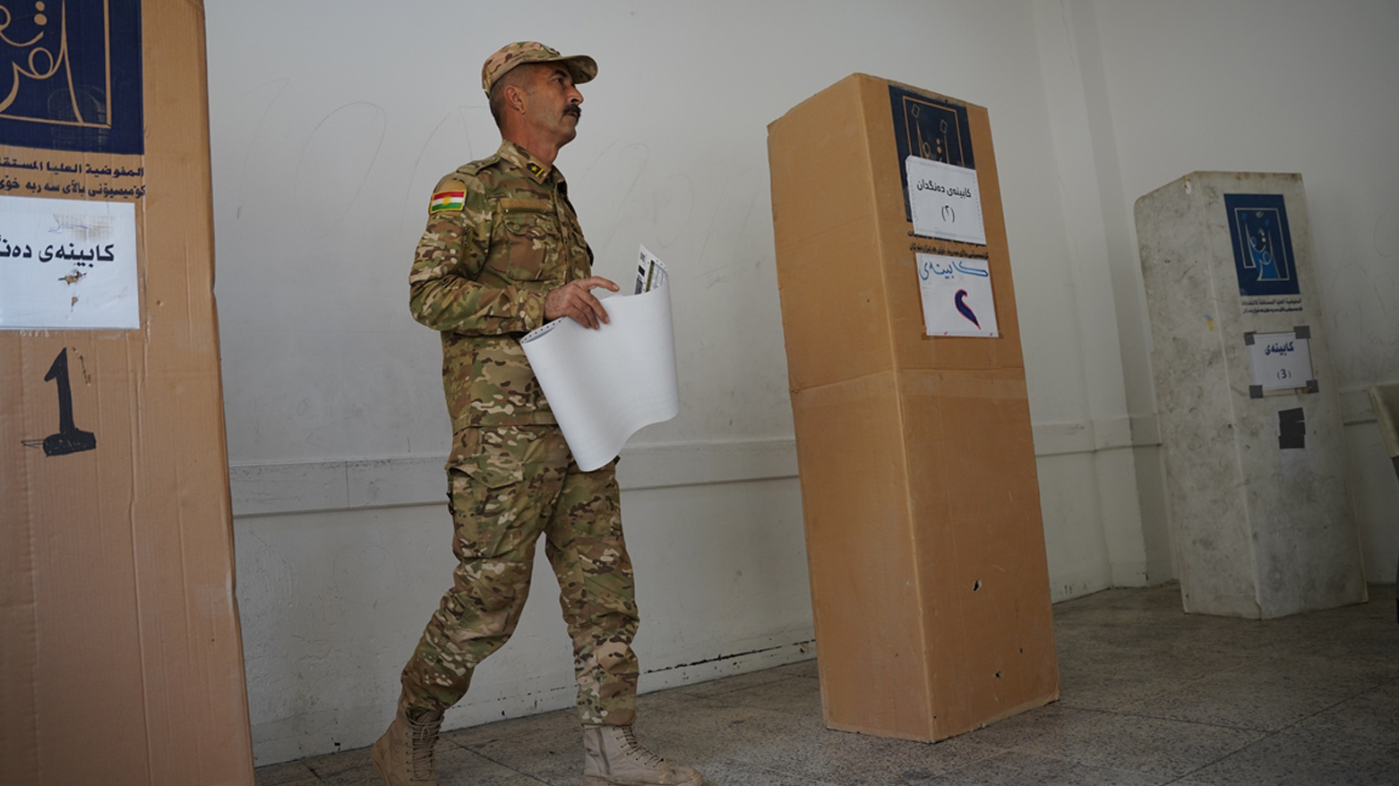 ئەندامێکی هێزە ئەمنییەکان لە کاتی دەنگدان