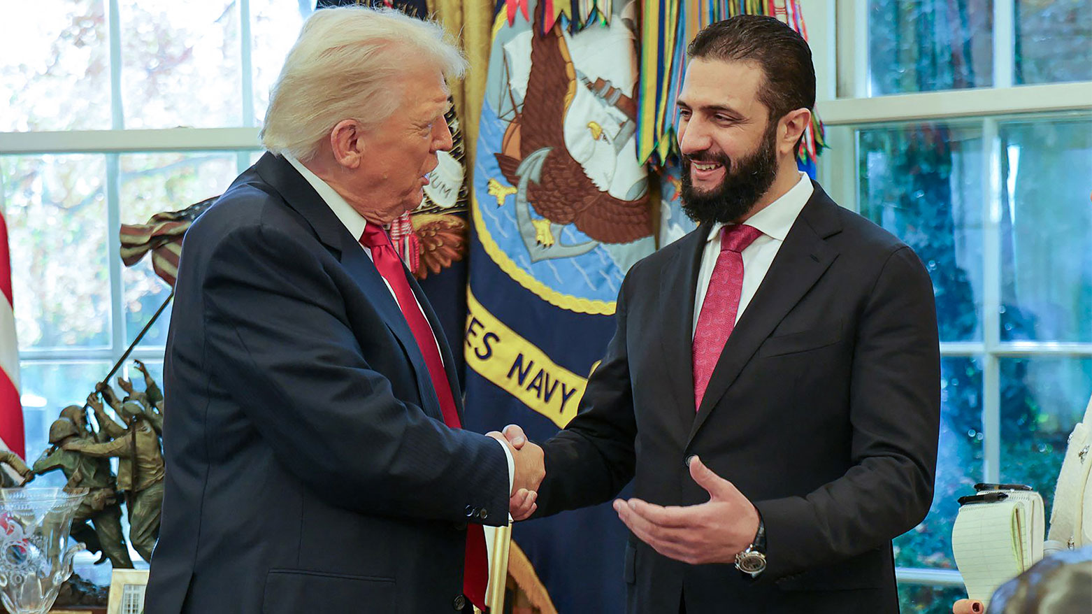 US President Donald Trump (l) shaking hands with Syria's President Ahmed al-Sharaa (R), Nov. 10, 2025. (AFP)