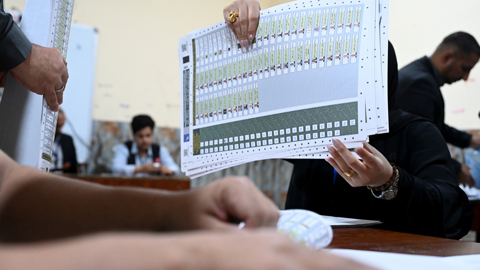 کارمەندێکی کۆمیسیۆن لە کاتی هەژمارکردنی دەنگەکان