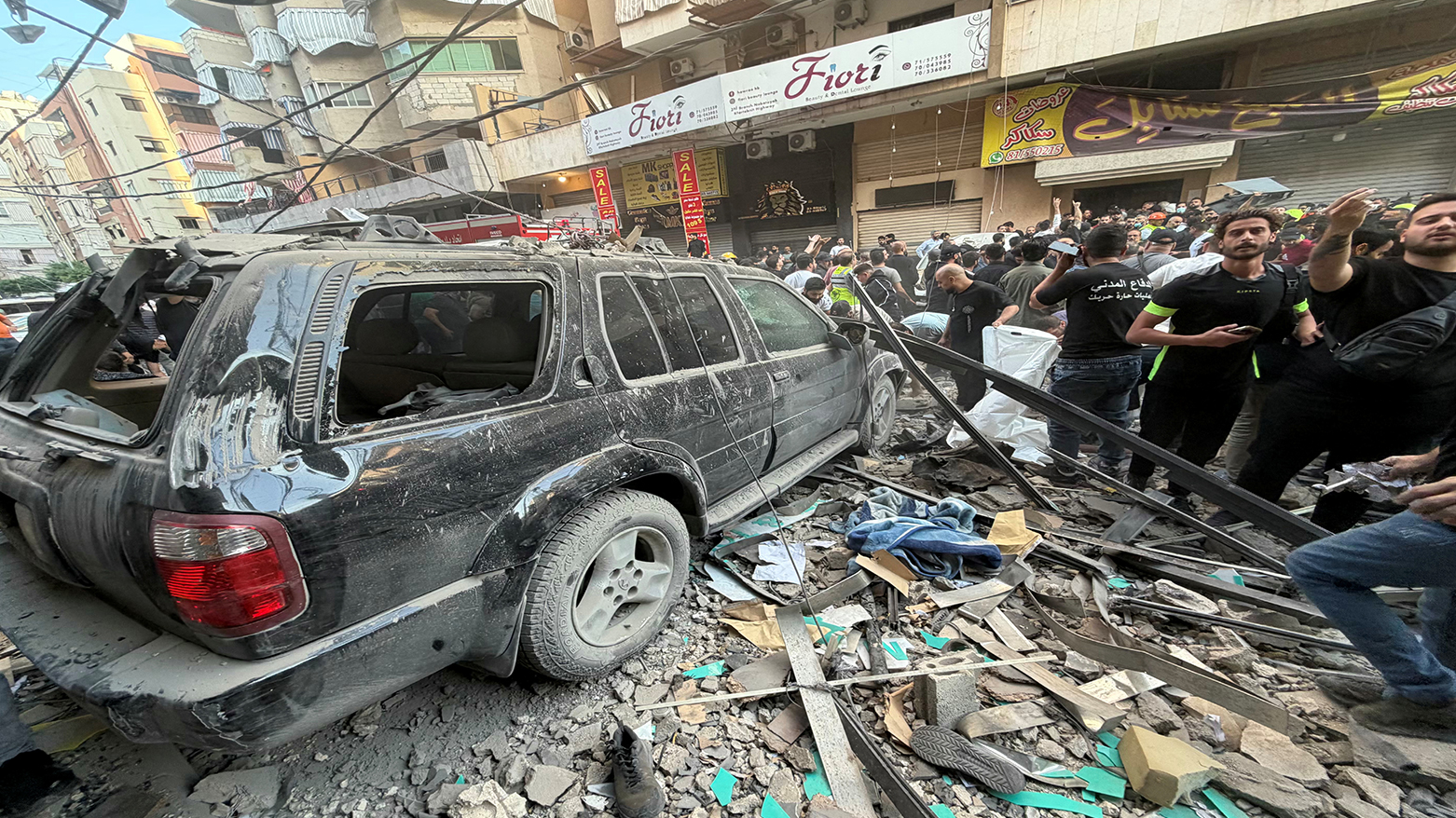 People gather as they look at the debris following an Israeli military strike targeting a residential building in the Haret Hreik neighbourhood, of Beirut's southern suburbs, Nov. 23, 2025. (Photo: AFP)