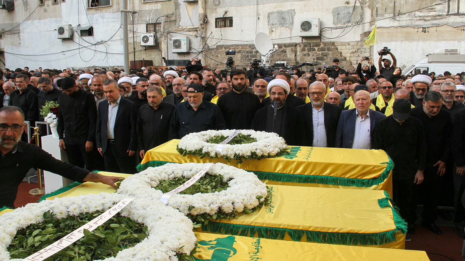 A cleric recites prayers over the coffins of top Hezbollah military chief Haytham Ali Tabatabai and others killed in an Israeli strike in Beirut’s southern suburbs, Nov. 24, 2025. (Photo: AFP)