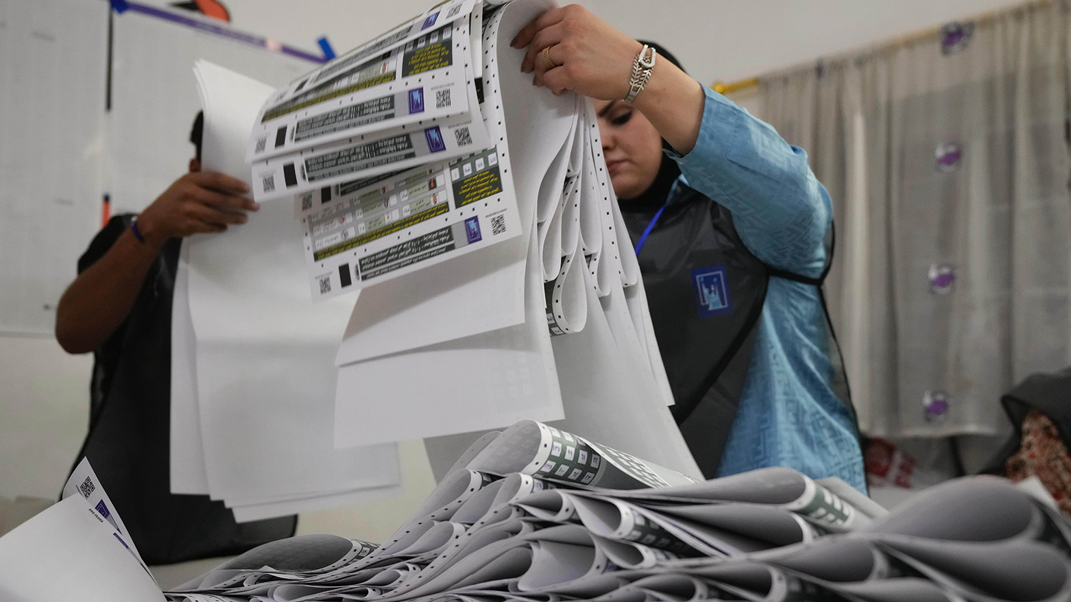 Election workers gather parliamentary election ballots after the polls closed in Baghdad, Iraq, Nov. 11, 2025. (AP)