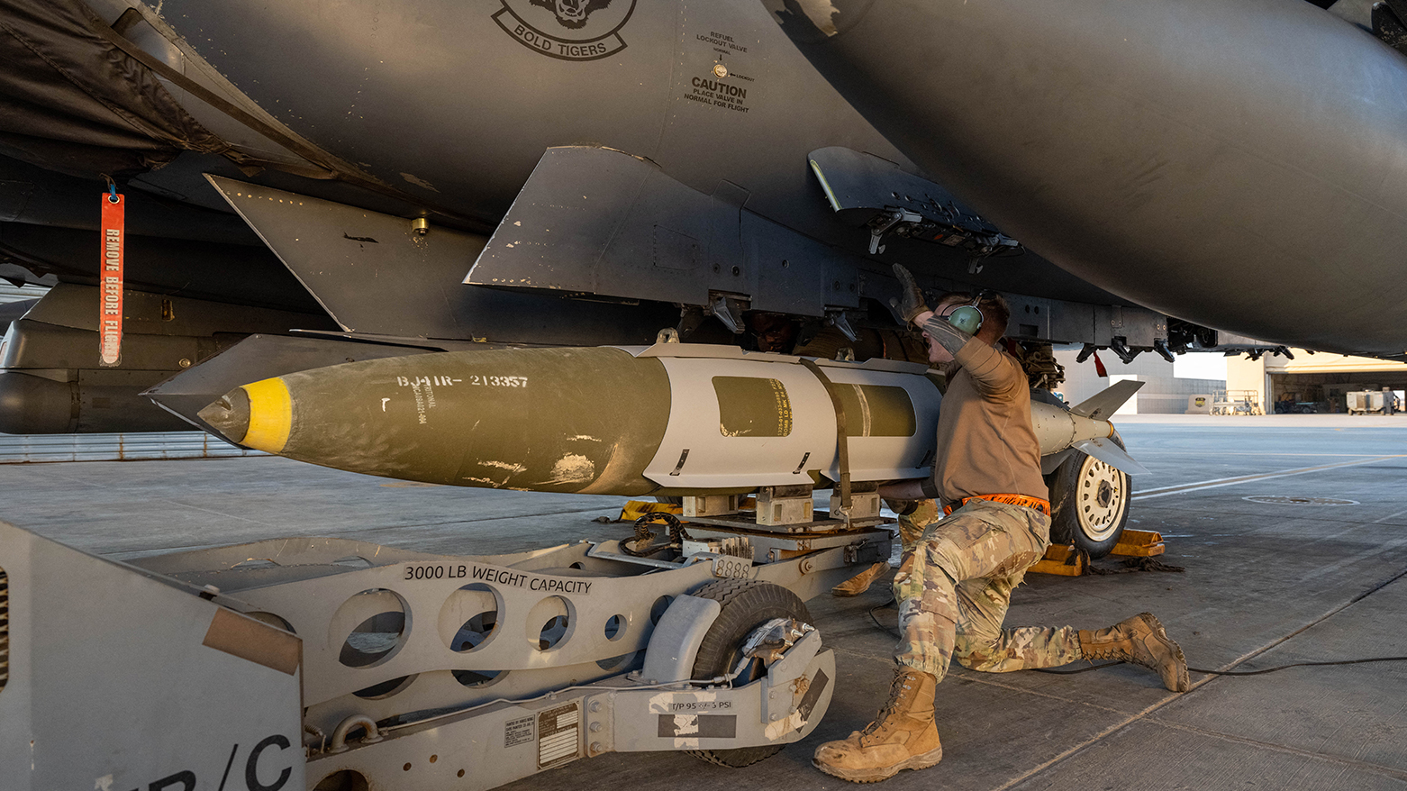 A US Airman attaches a GBU-31 munitions system to an F-15E Strike Eagle in the US Central Command area of responsibility, in support of Operation Hawkeye Strike, Dec. 18, 2025. (US Army)