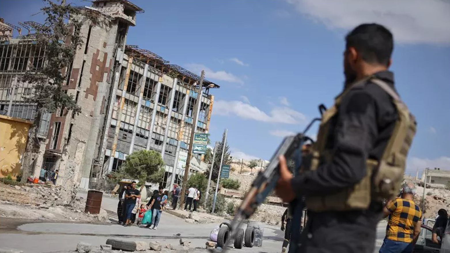 Syrian security forces stand guard as residents leave the Sheikh Maqsoud and Achrafieh neighborhoods of Aleppo, Syria, Oct. 7, 2025. (AP)