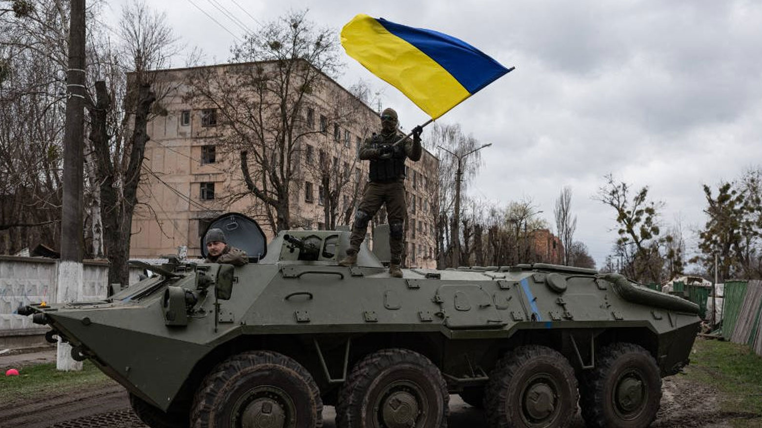 جندي أوكراني على ظهر مدرعة يرفع علم بلاده (رويترز)