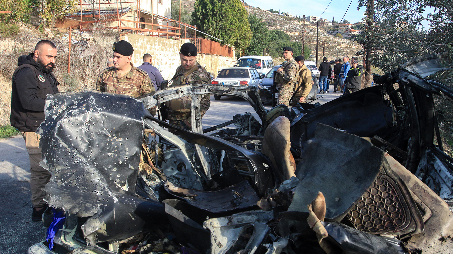 Lebanese army soldiers stand next to the wreckage of a car that was trageted in an Israli air strike in Mazraat al Qnaitra on Dec. 22, 2025. (AFP)