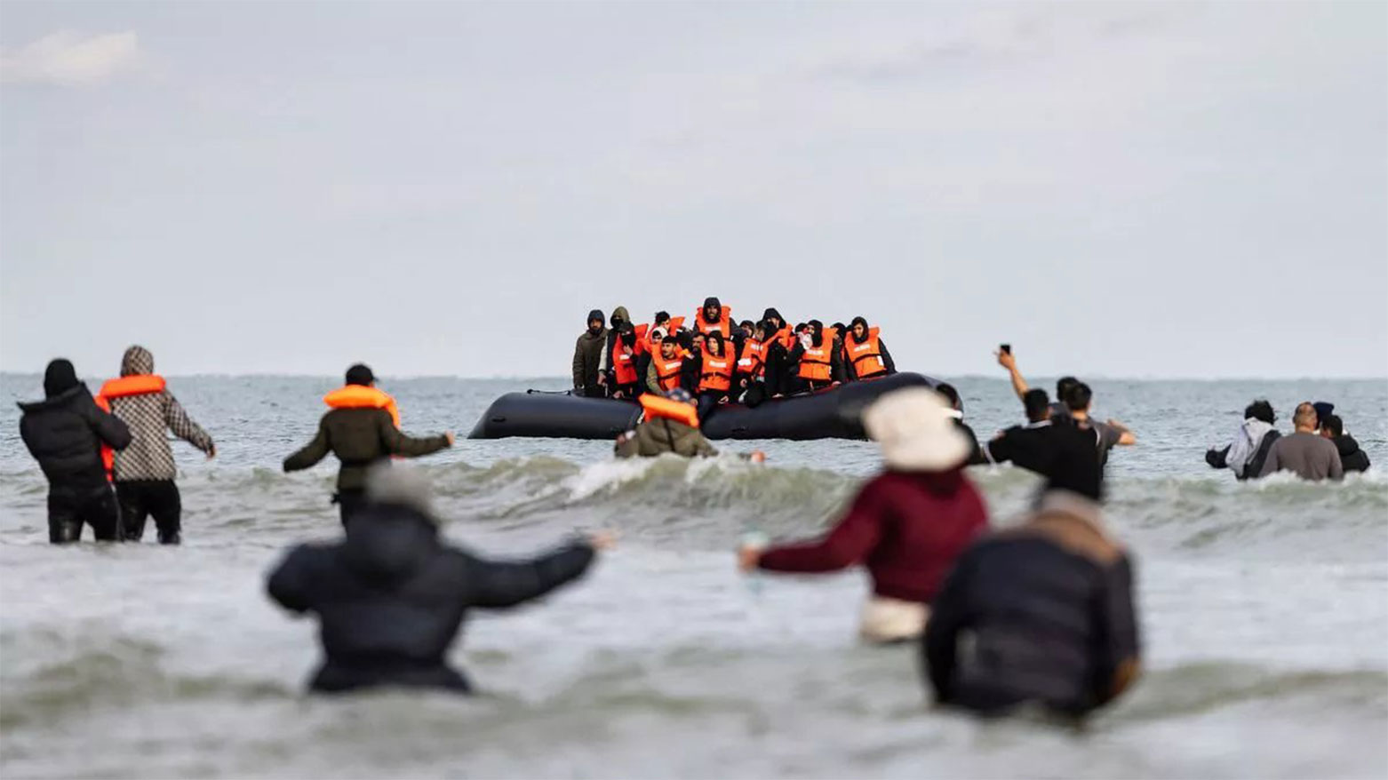 Migrants wave to a smuggler's boat in an attempt to cross the English Channel, near Dunkirk, northern France on April 26, 2024. (Photo: AFP)