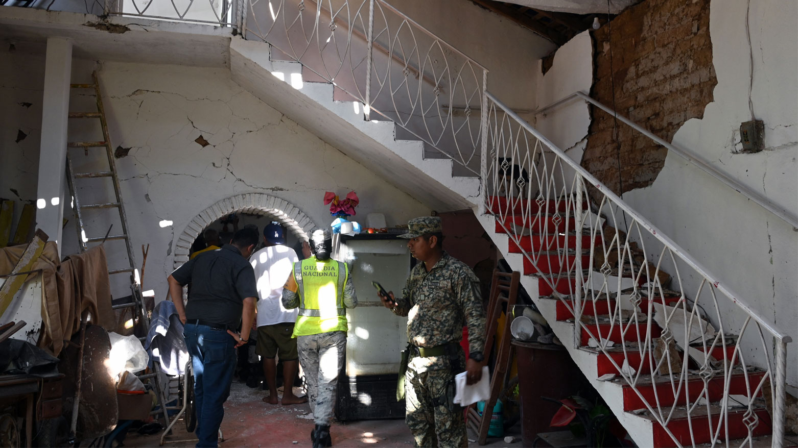 أفراد من الحماية المدنية والجنود المكسيكيون يتفقّدون منزل متضرر في بلدة سان ماركوس بولاية غيريرو في المكسيك (فرانس برس)