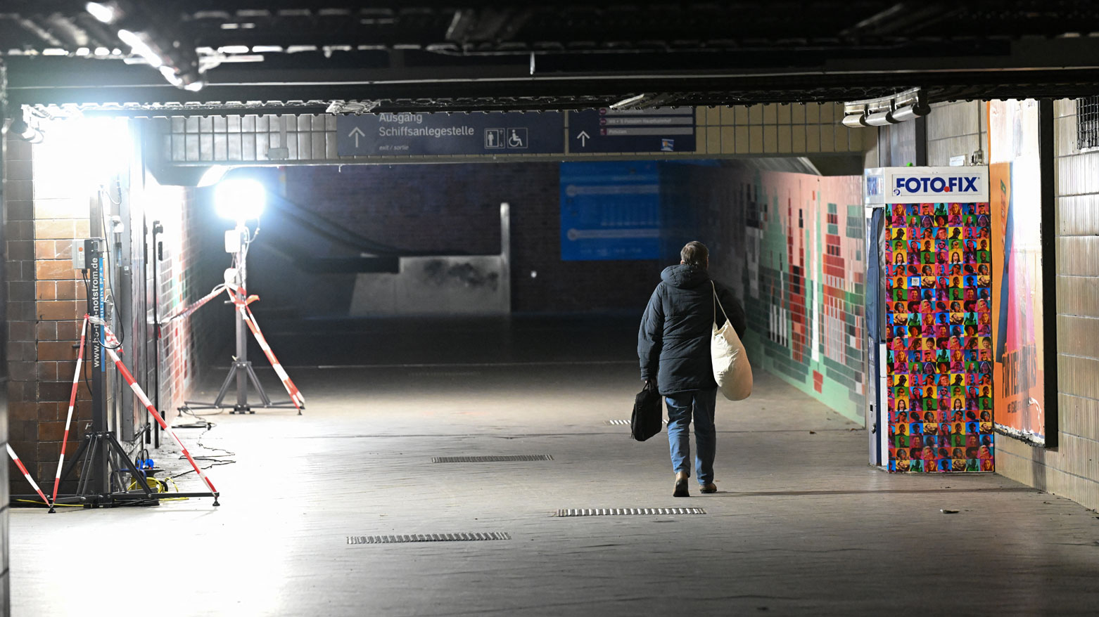 يسير أحد الركاب على طول ممر في محطة قطار المتوقفة عن الخدمة والتي أضاءتها الوكالة الفيدرالية للإغاثة التقنية (THW) في جنوب غرب برلين (فرانس برس)