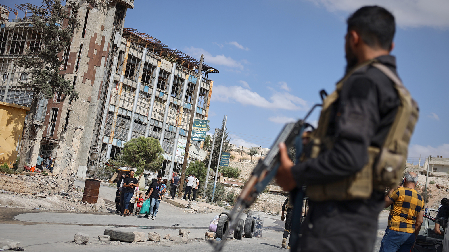 Syrian security forces stand guard as residents leave the Sheikh Maqsoud and Achrafieh neighborhoods of Aleppo, Syria, Tuesday, Oct. 7, 2025. (AP)