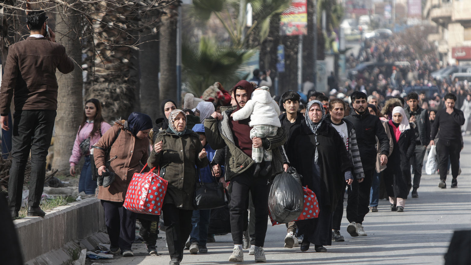 يحمل السكان أمتعتهم أثناء فرارهم من حي الأشرفية ذو الغالبية الكوردية في حلب- 7 يناير 2026 بسبب القصف الحكومي (فرانس برس)